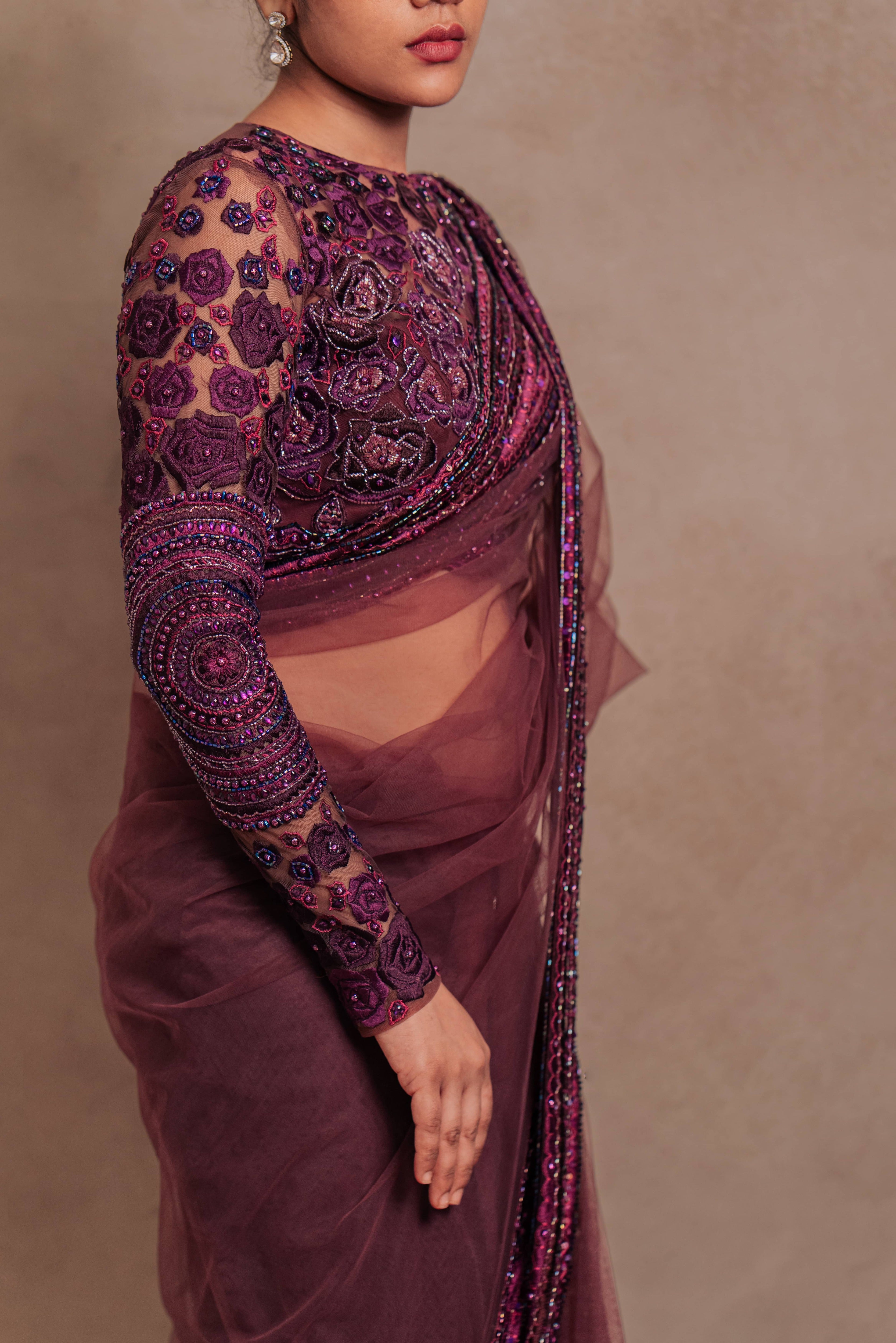 Jaina Parmar, known for recreating looks of actress Nayanthara is seen here in a purple net saree with heavily embellished border and full sleeved blouse with stone and resham work posing for closeup of side profile