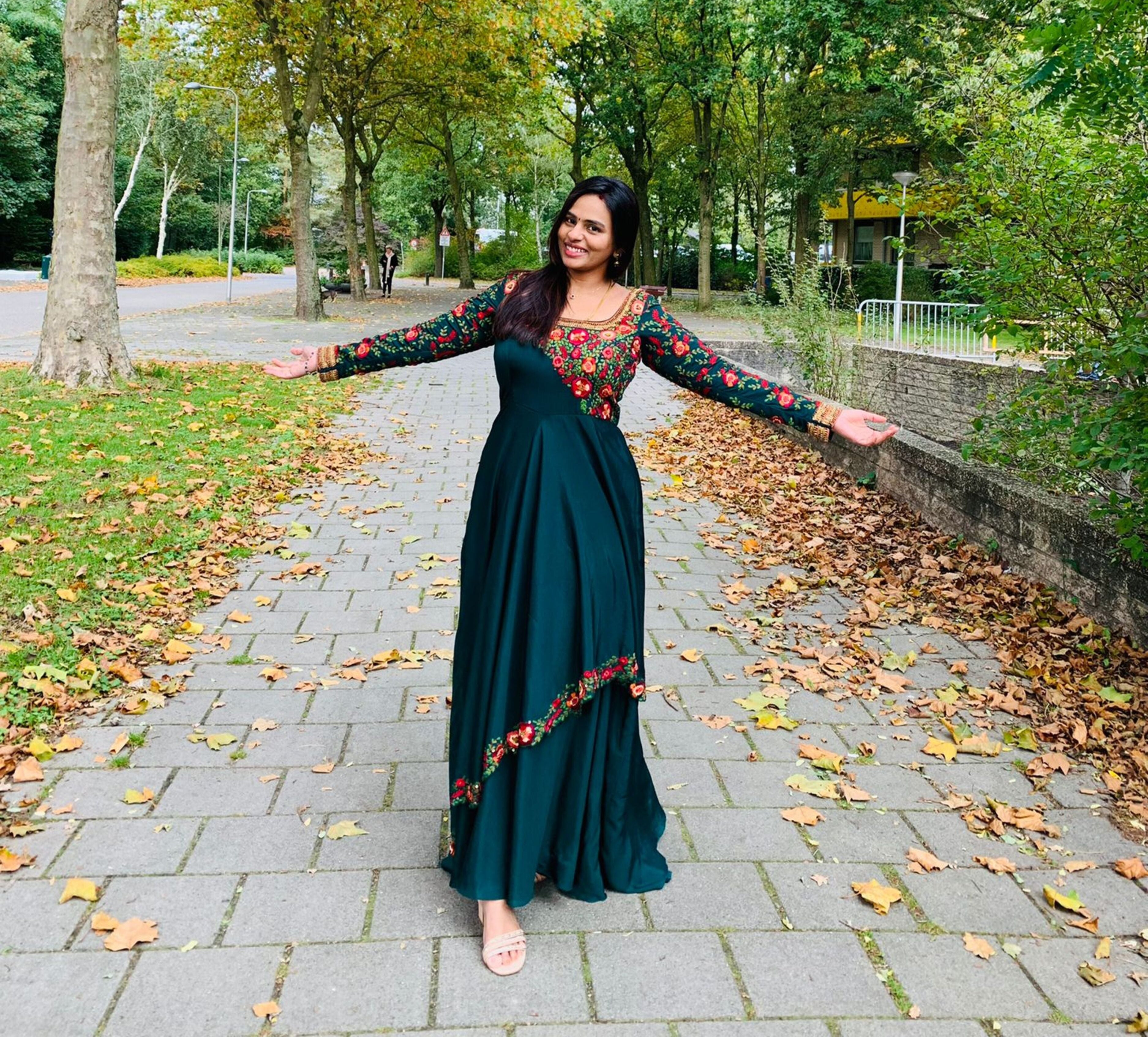 Kowsalya fro Buffalo, USA in an a green multi-layered anarkali designed by Archana Karthick. Straight at the camera with arms wide open.
