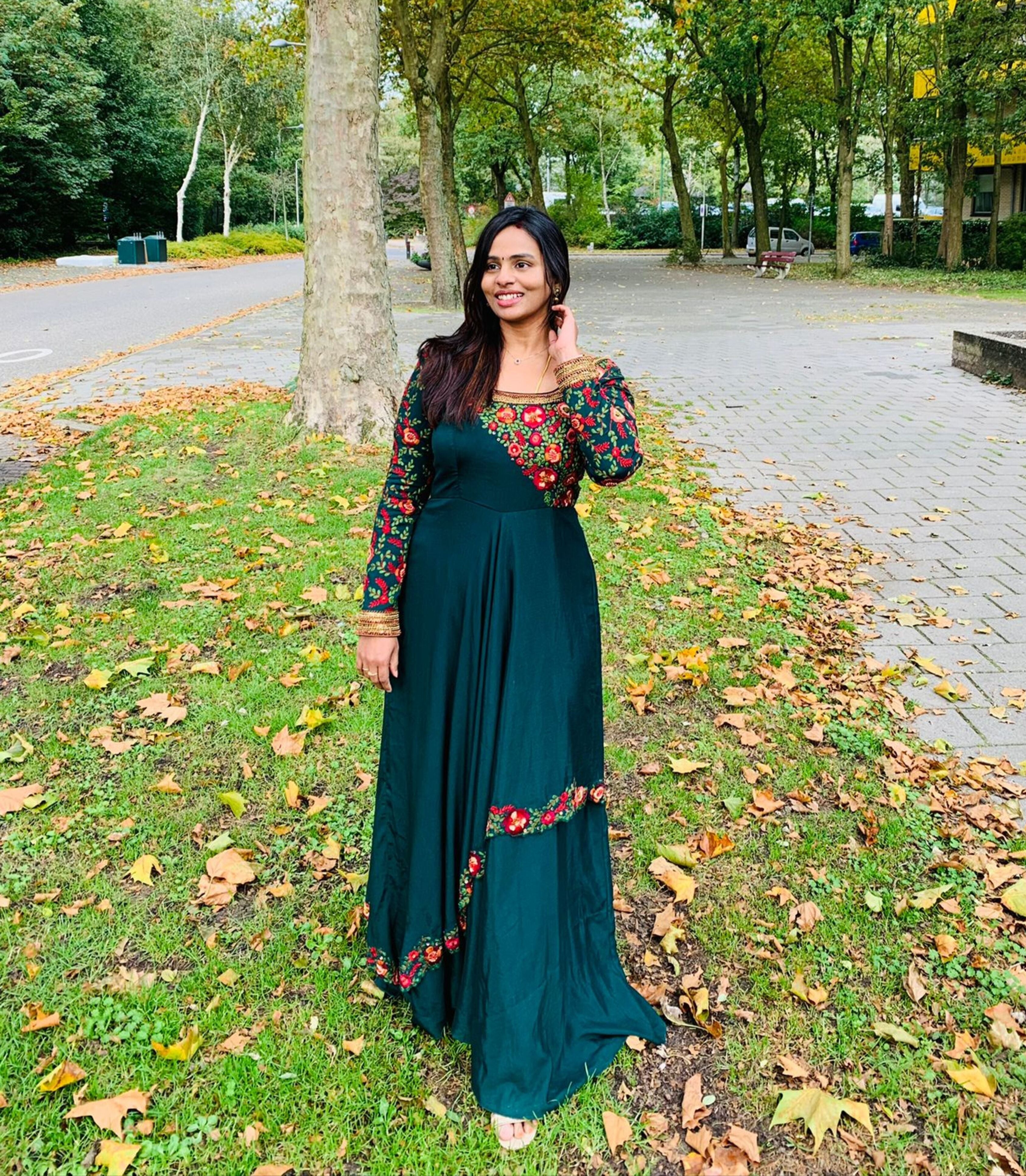 Kowsalya fro Buffalo, USA in an a green multi-layered anarkali designed by Archana Karthick. Straight at the camera with one hand setting her hair.