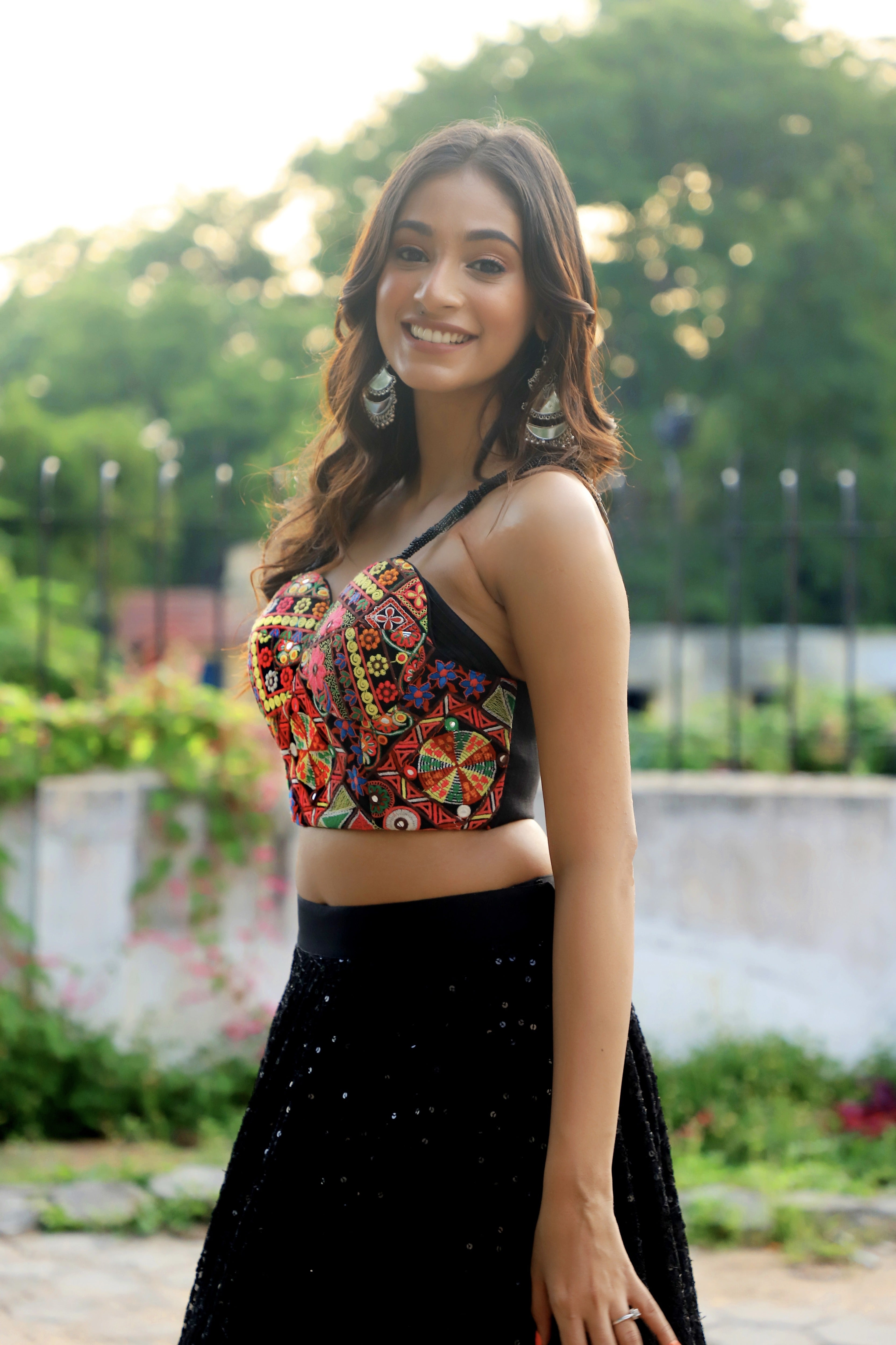 Miss India 2018 and actress Anukreethy Vas in a partywear corset and skirt. Smiling at camera side profile.