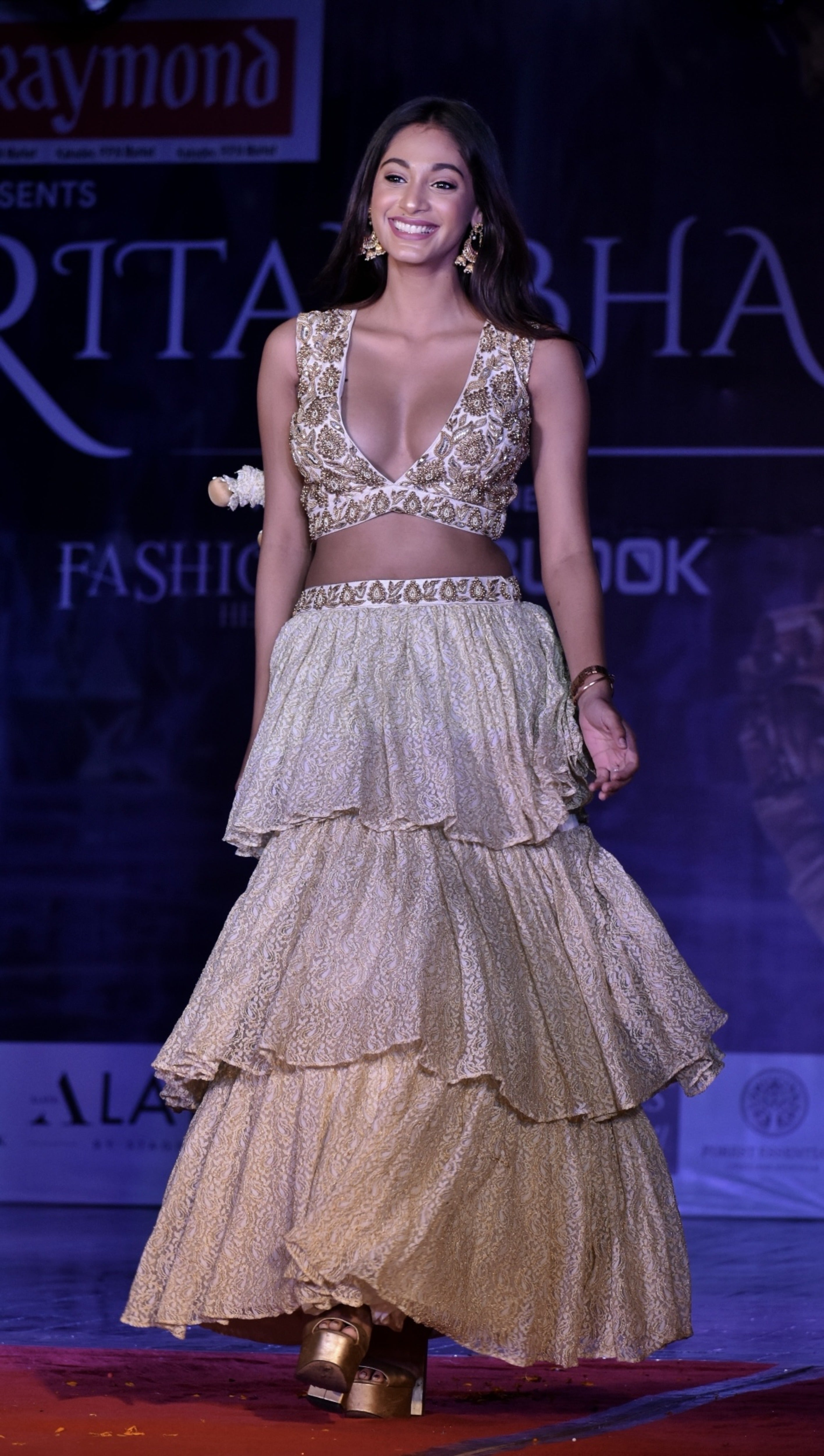 Miss India 2018 and actress Anukreethy Vas walking the ramp in a plunge neck crop top and layered skirt in ivory designed by Archana Karthick. Posing with a smile.