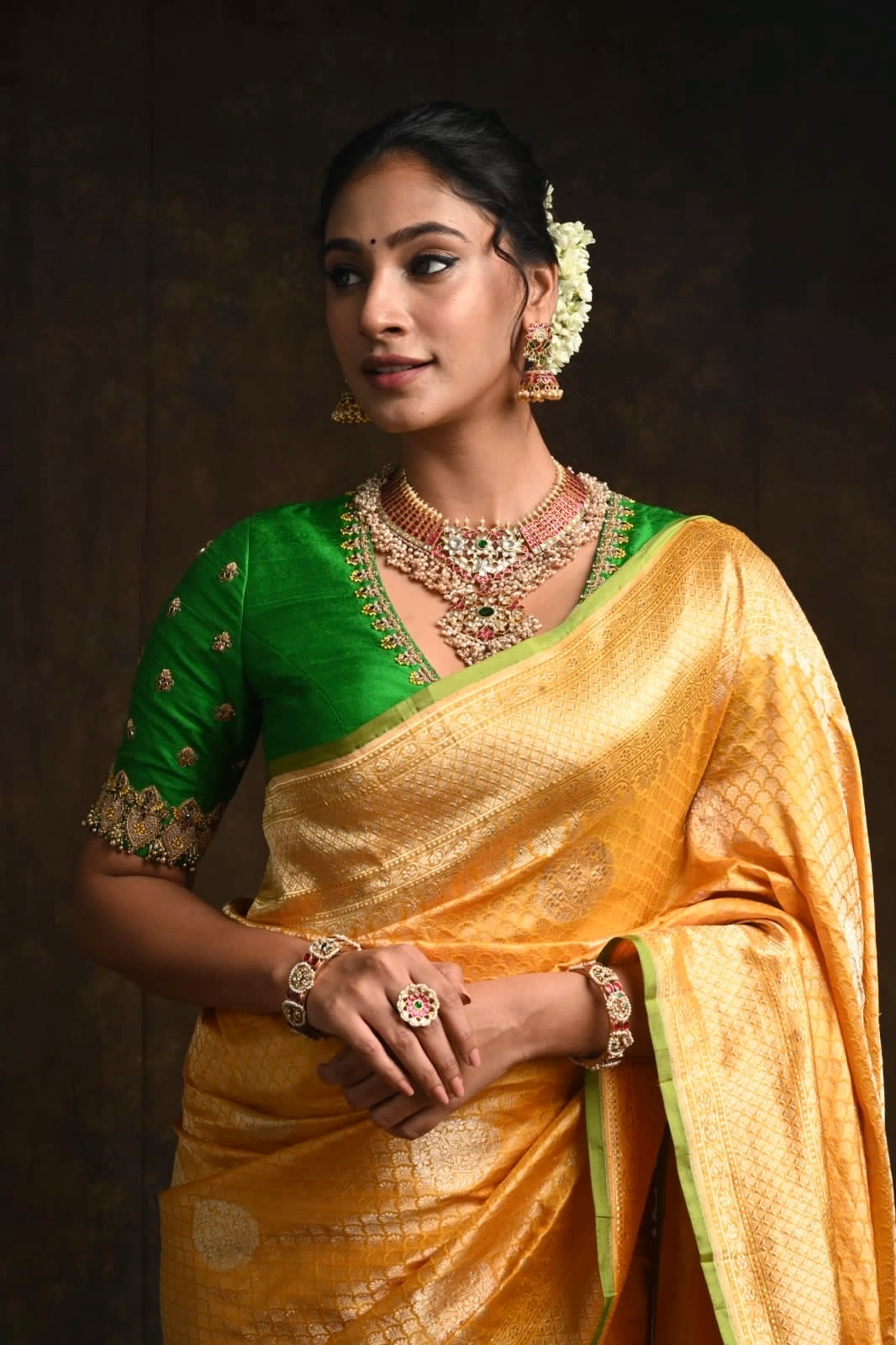 Miss India and Actress Anukreethy Vas posing in a green raw silk blouse, intricately handcrafted with beads, zardozi, crystals and zari knots by team Archana Karthick.