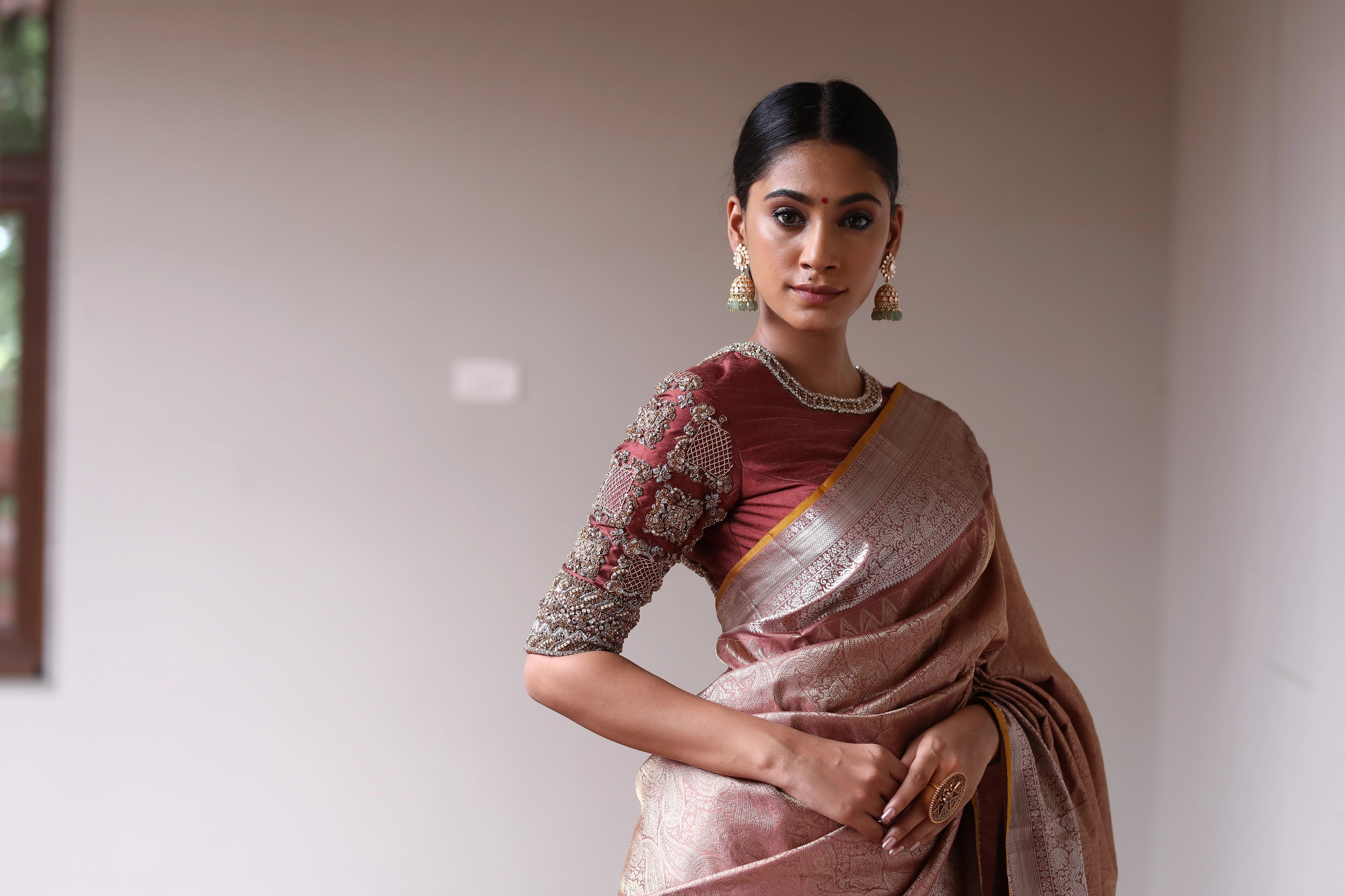 Miss India and Actress Anukreethy Vas posing in a rose gold raw silk blouse, intricately handcrafted with pearls, zardozi, stones and zari by team Archana Karthick.