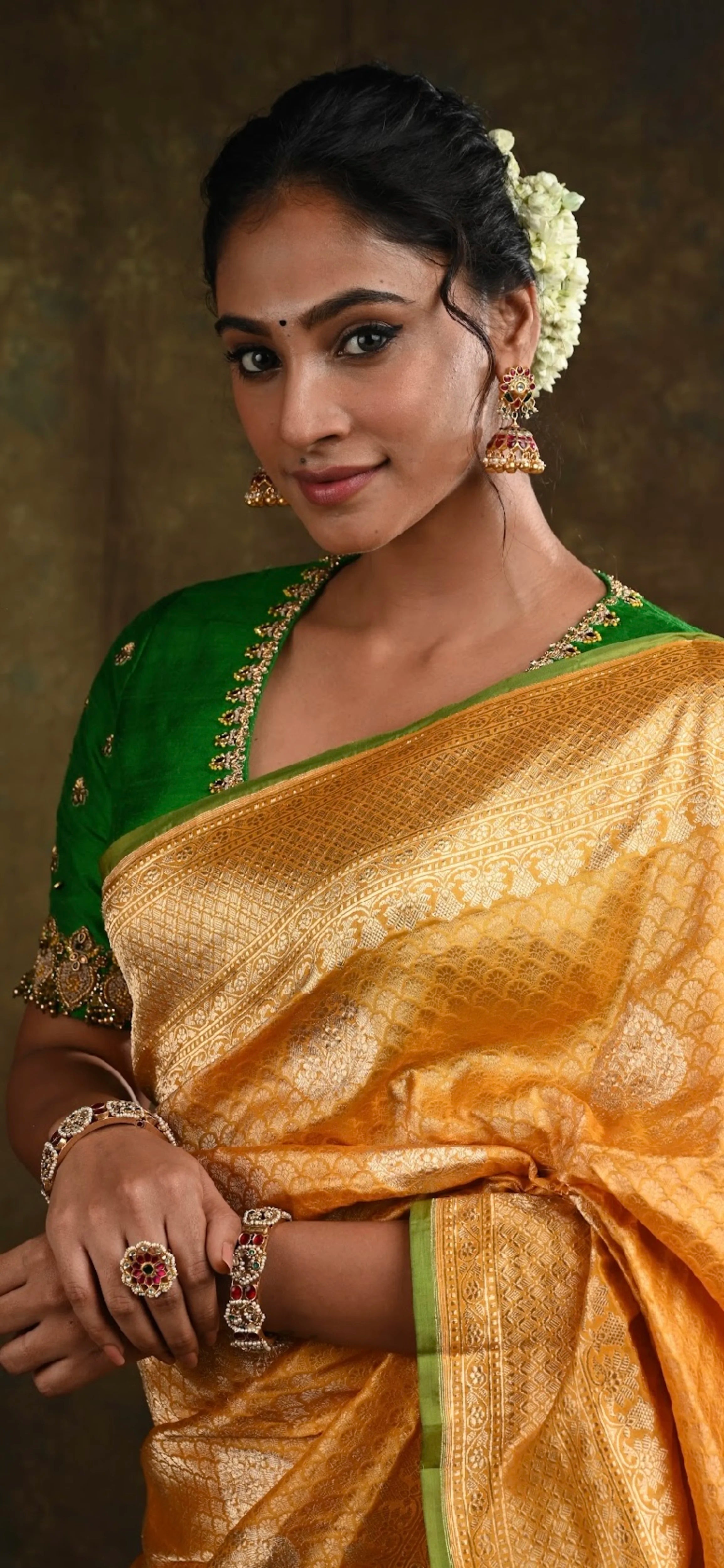 Miss India and Actress Anukreethy Vas smiling in a green raw silk blouse, intricately handcrafted with beads, zardozi, crystals and zari knots by team Archana Karthick.