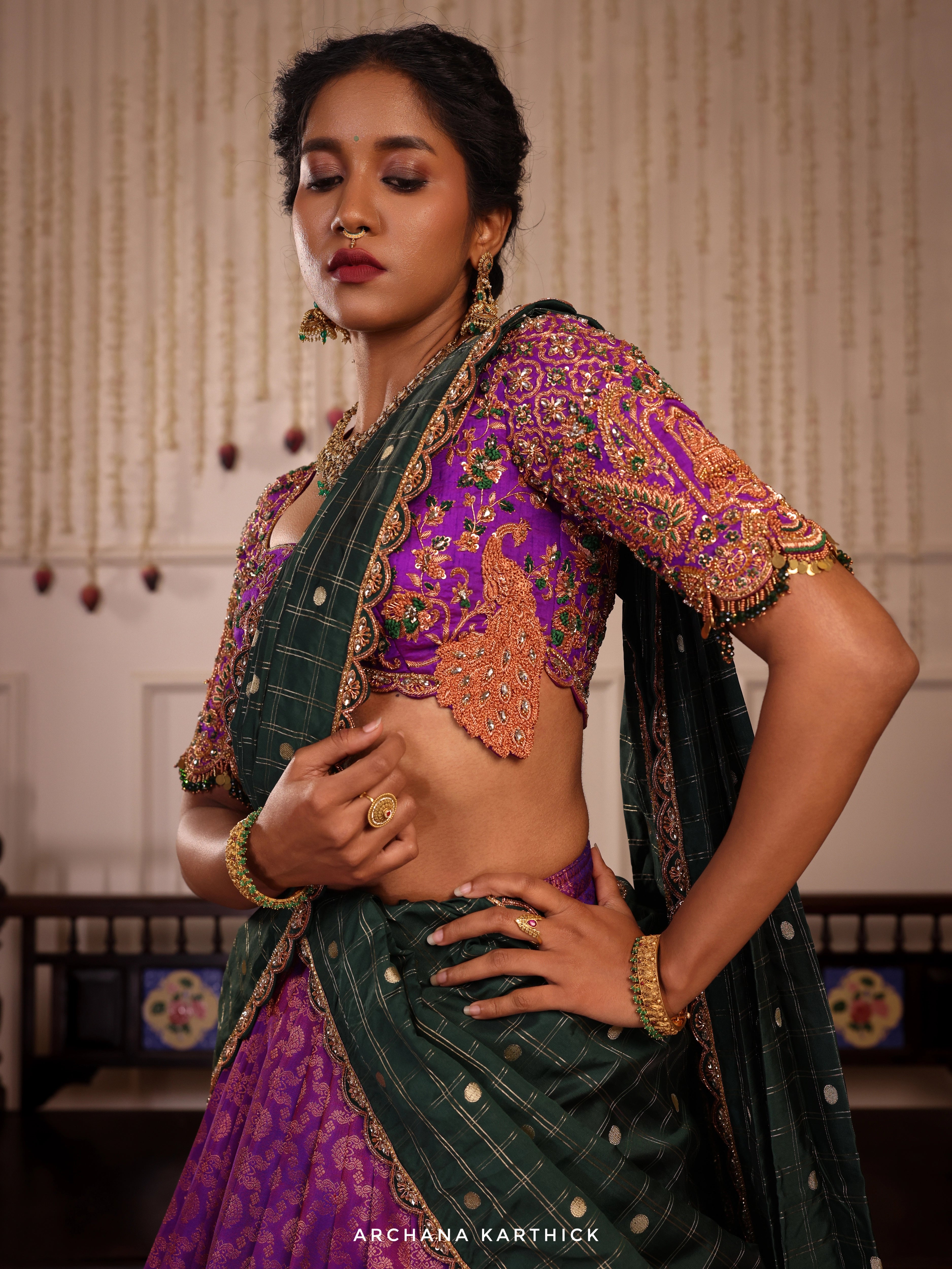 Model Gayathri Dhanasekar poses  in  purple and bottle green kanjeevaram silk half saree with jewelry by vummidi bangaru jewellers