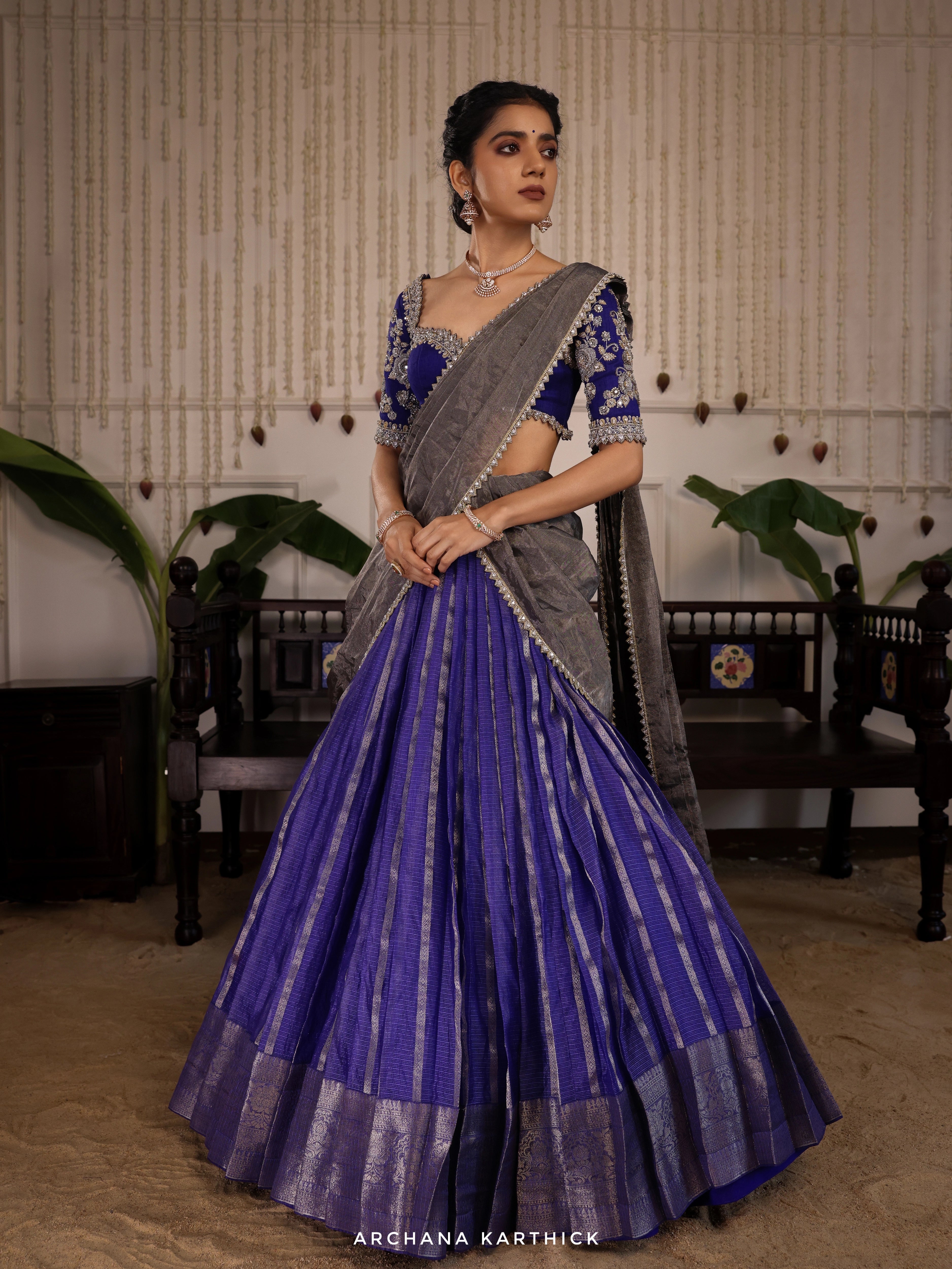 Model Himanshi posing in a blue and silver kota silk half saree with from vummidi bangaru diamond jewellery