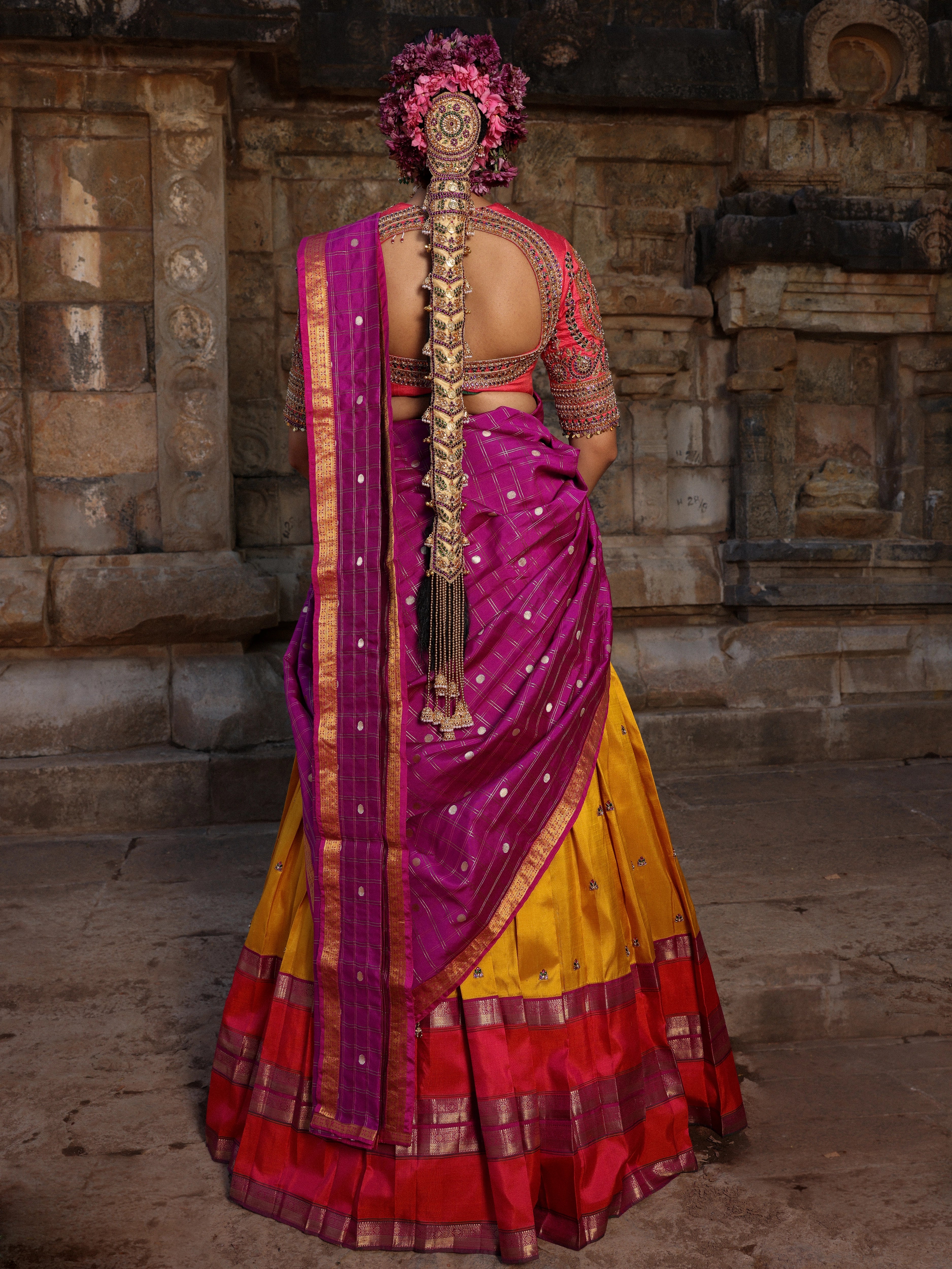 Model Anyuktha Nallani posing in pink yellow and purple kanjeevaram silk half saree by chennai-based luxury couture label Archana Karthick