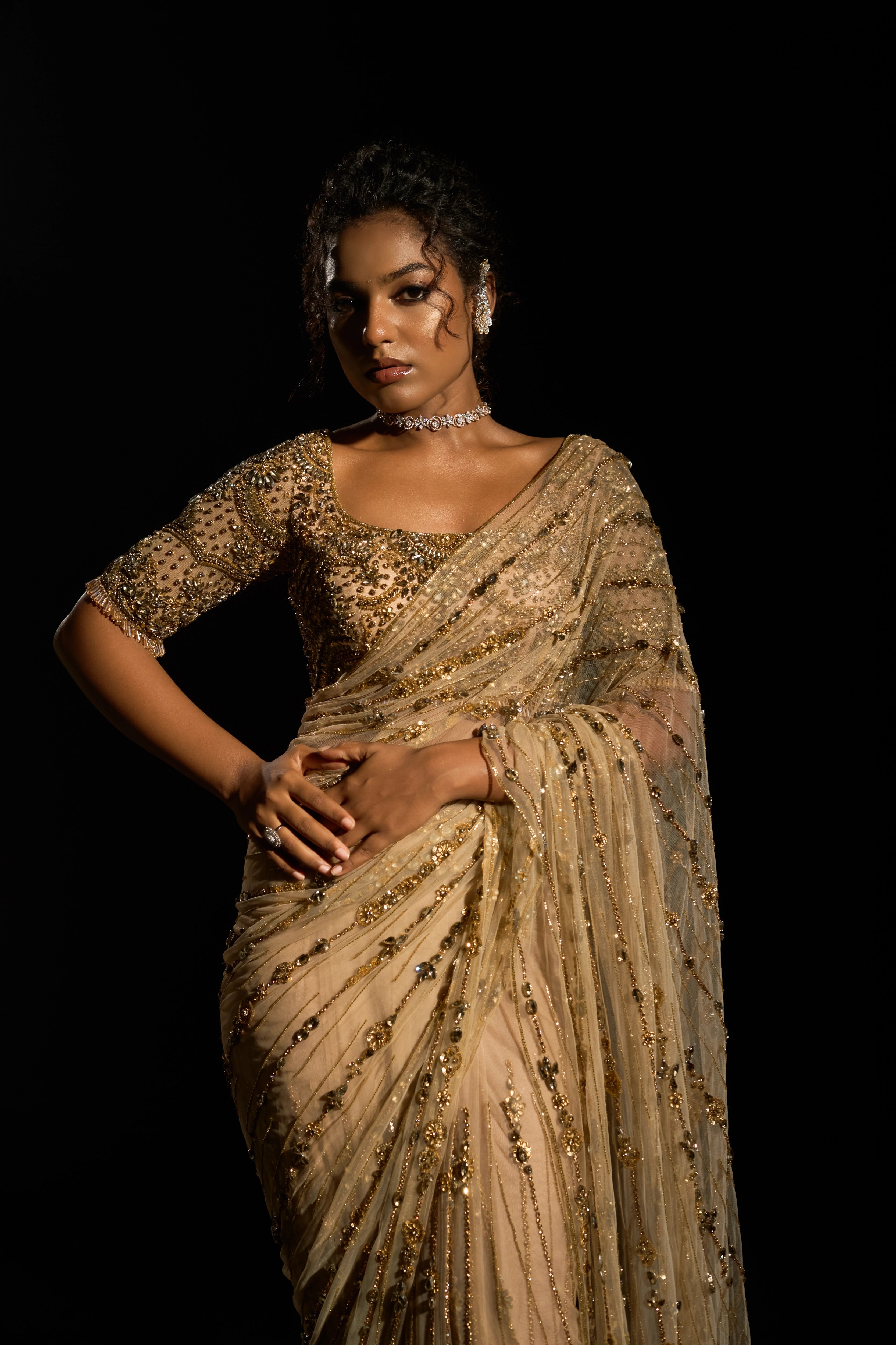 Model Ashika Crystal showcasing front detailings in a gold saree set intricately adorned with sequins, rhinestones, crystals and cutdana for "STARDUST" - A/W'25 saree collection by team Archana Karthick.