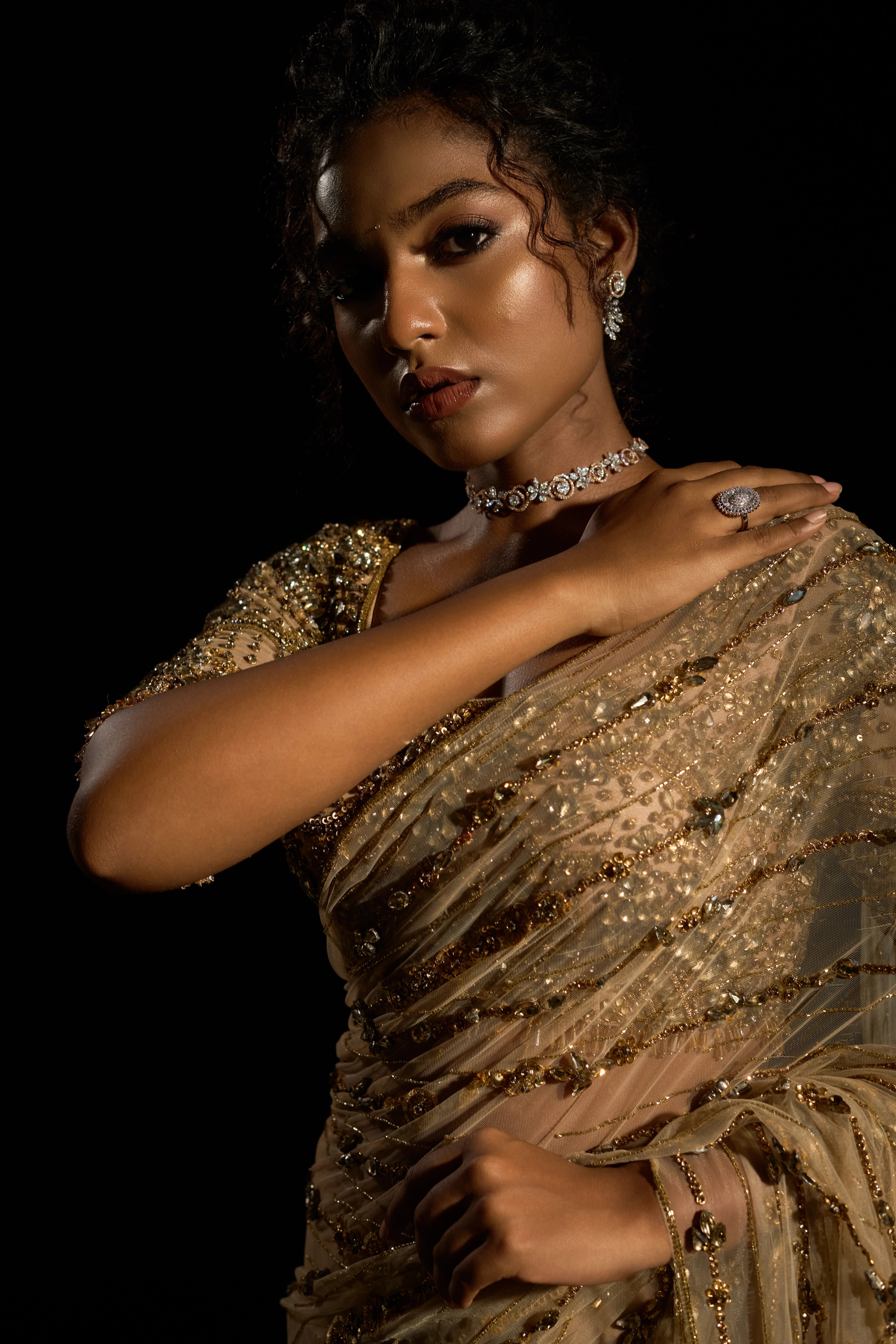 Model Ashika Crystal showcasing saree detailing in a gold saree set intricately adorned with sequins, rhinestones, crystals and cutdana for "STARDUST" - A/W'25 saree collection by team Archana Karthick.