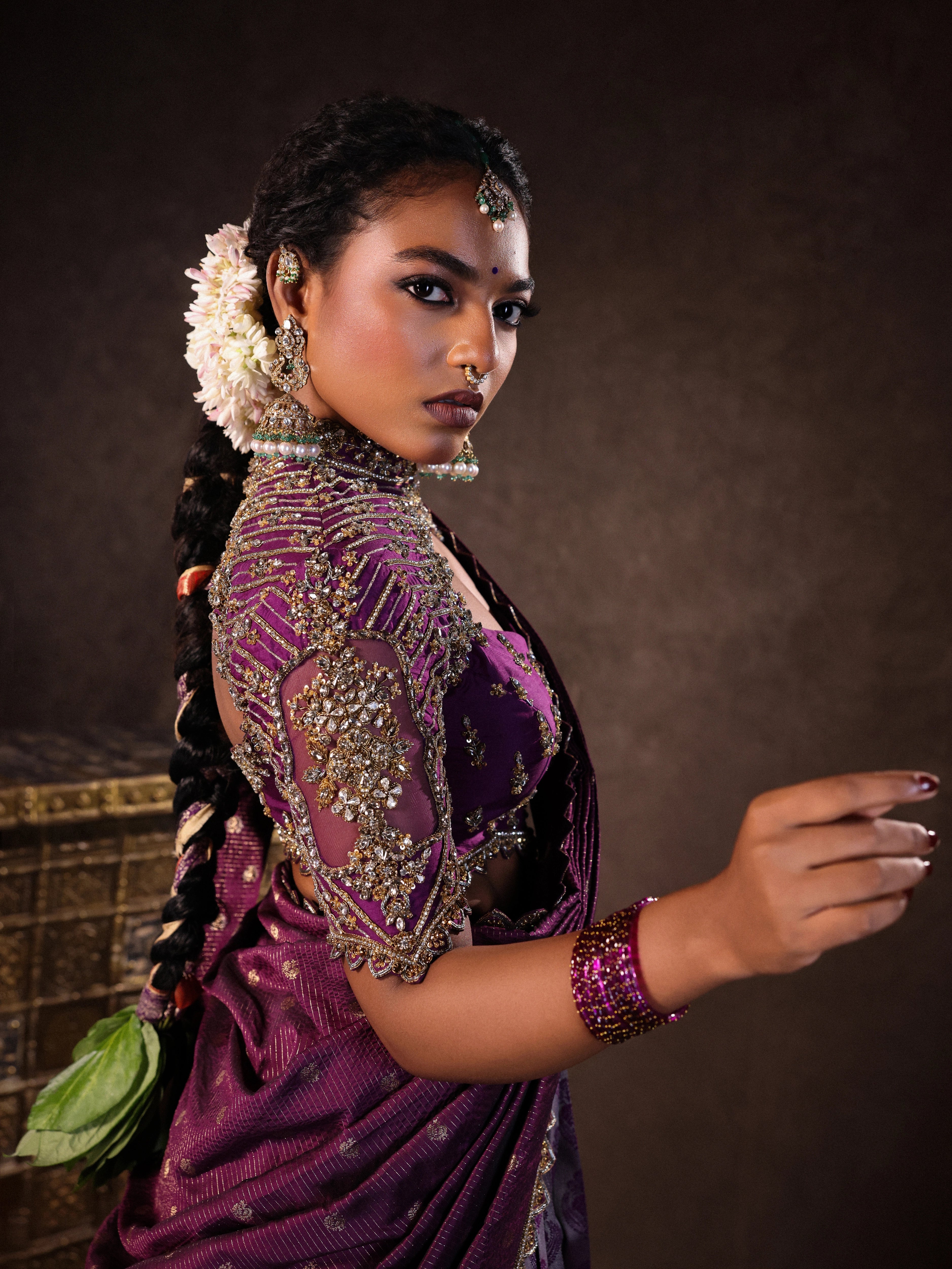 Model Ashika Crystal showcasing sleeve in a silk half saree set in purple, handcrafted with zardozi, sequins and rhinestones. Team Archana Karthick completed the style with purple glass bangles, a ring, jhumkas, nose ring and a maang tikka.