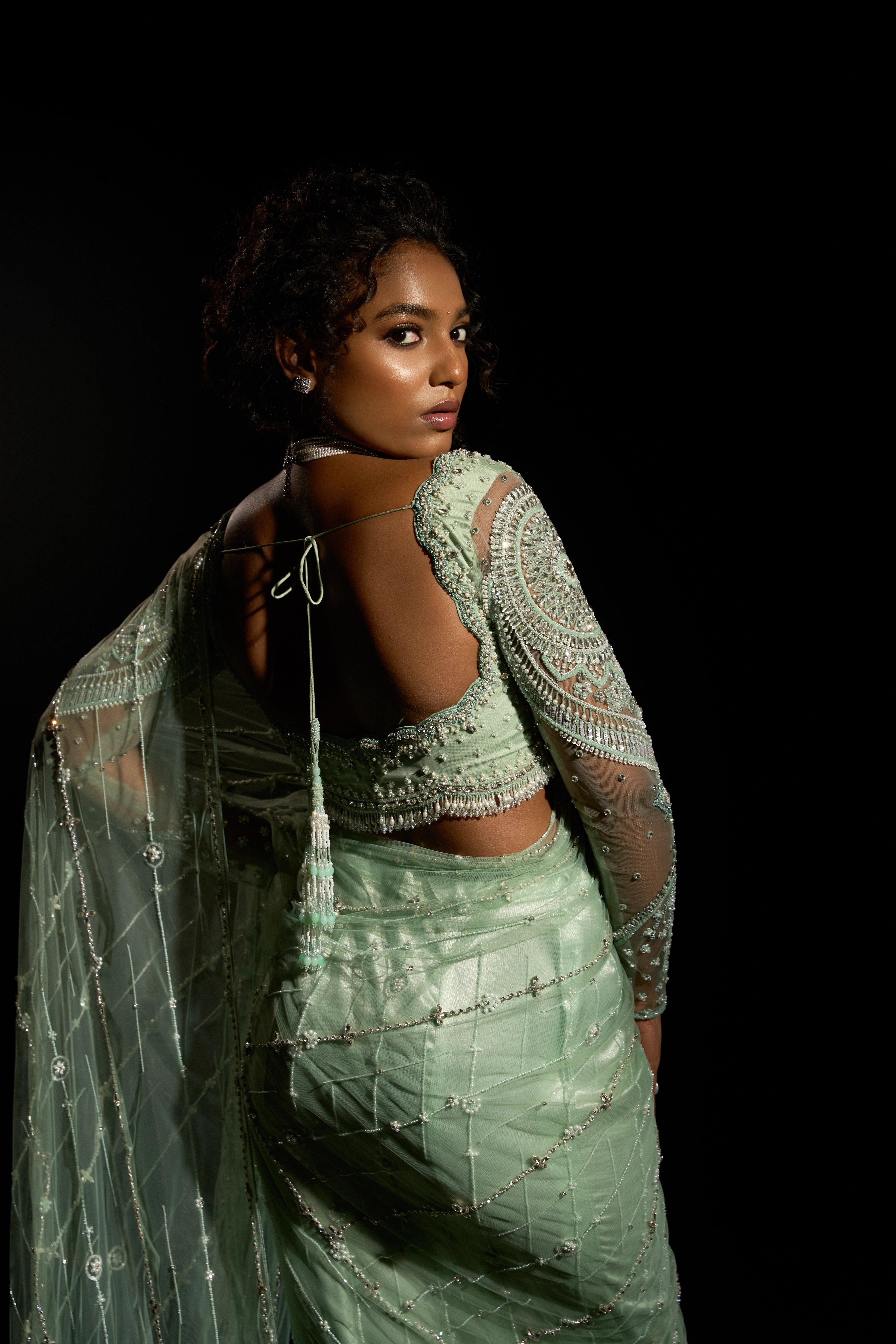 Model Ashika Crystal showcasing the back design in a green saree set intricately adorned with sequins, rhinestones, crystals and cutdana for "STARDUST" - A/W'25 saree collection by team Archana Karthick.