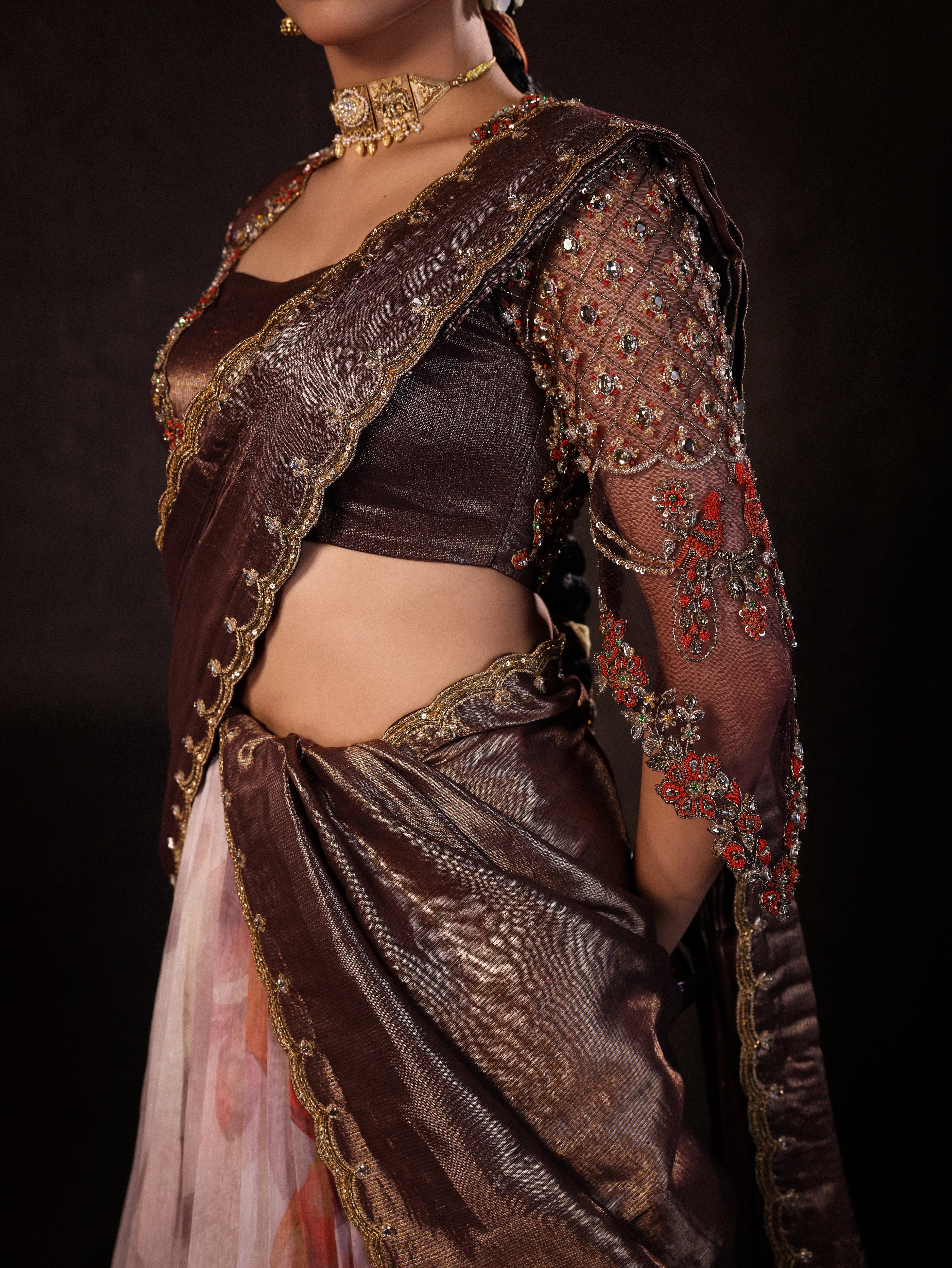 Model Dr Sree Advaita showcasing detailing in a brown & printed ivory silk half saree set handcrafted with zardozi, resham, cutdana, sequins & rhinestones. Team Archana Karthick completed the style with brown glass bangles, a ring, jhumkas, nose ring and a maang tikka.
