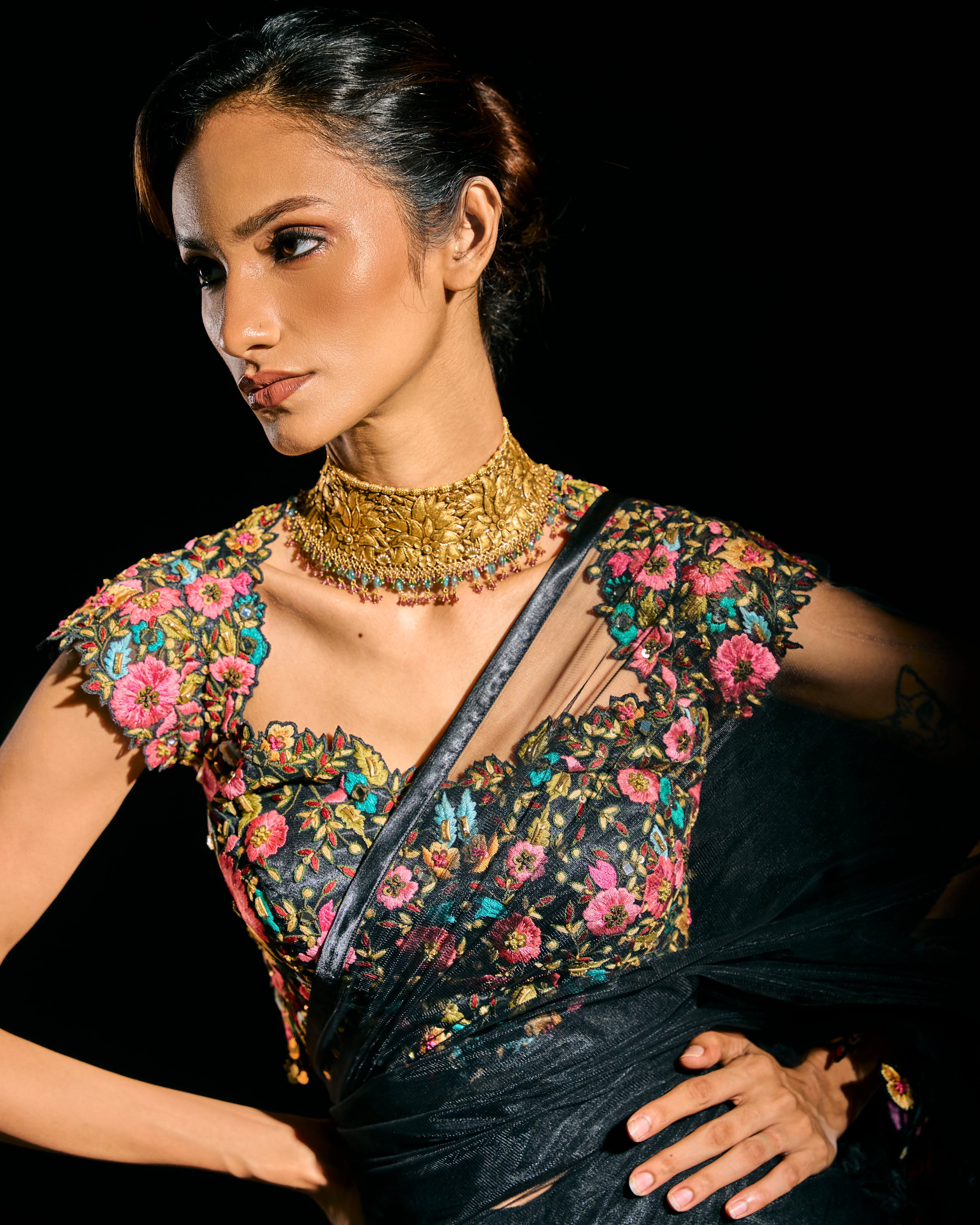 Model Esha Gohil in a closeup in black tulle drape and embroidered with floral resham that gleam like whispers in the dark. Handcrafted for "HAZE" - A/W'25 capsule collection by Archana Karthick.