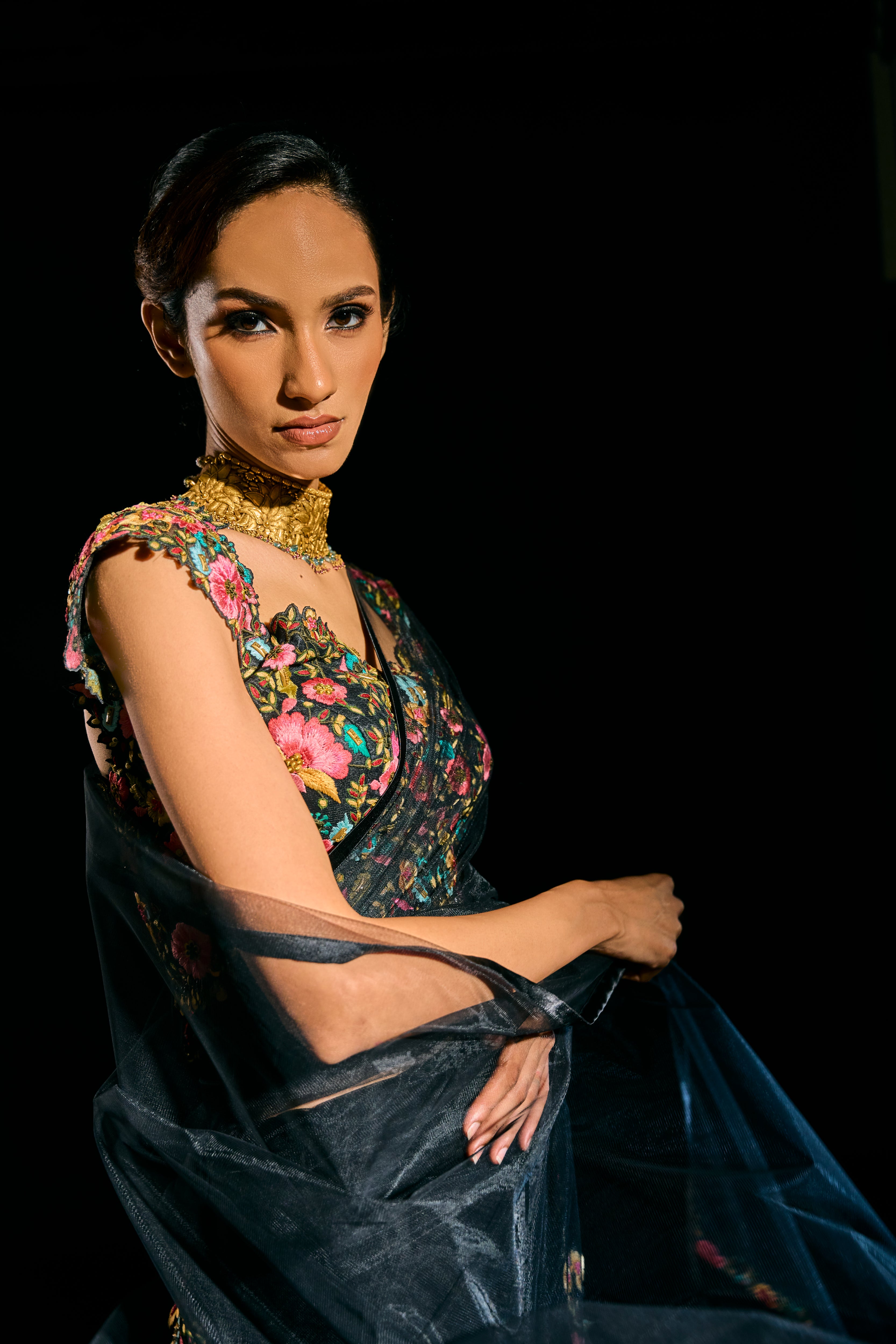Model Esha Gohil in a closeup shot in black tulle drape and embroidered with floral resham that gleam like whispers in the dark. Handcrafted for "HAZE" - A/W'25 capsule collection by Archana Karthick.