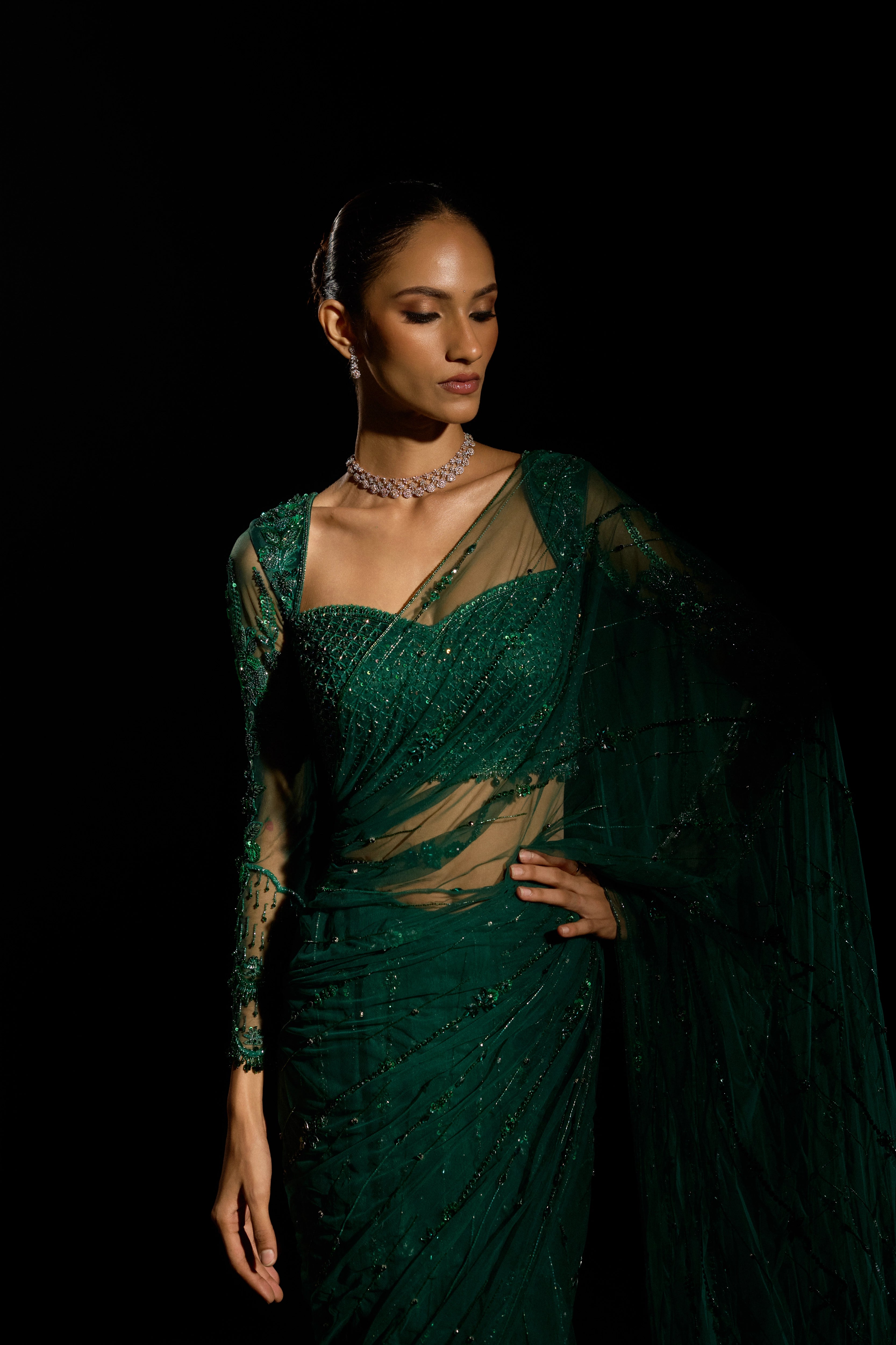 Model Esha Gohil posing for a photoshoot in a bottle green saree set is intricately adorned with sequins, rhinestones, crystals and cutdana for "STARDUST" - A/W'25 saree collection by team Archana Karthick.
