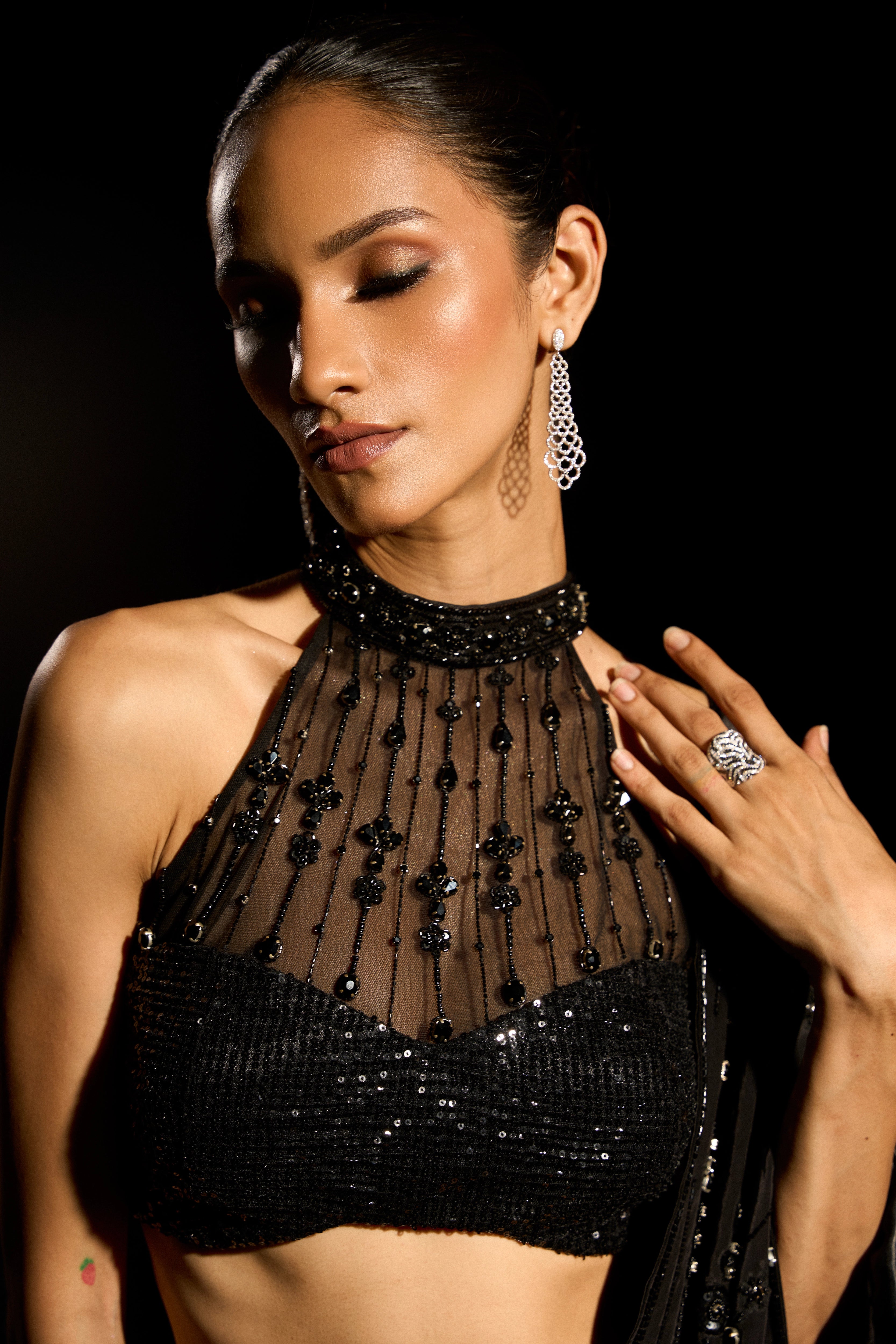 Model Esha Gohil posing for closeup during photoshoot in a black saree set is intricately adorned with sequins, rhinestones and cutdana for "STARDUST" - A/W'25 saree collection by team Archana Karthick.