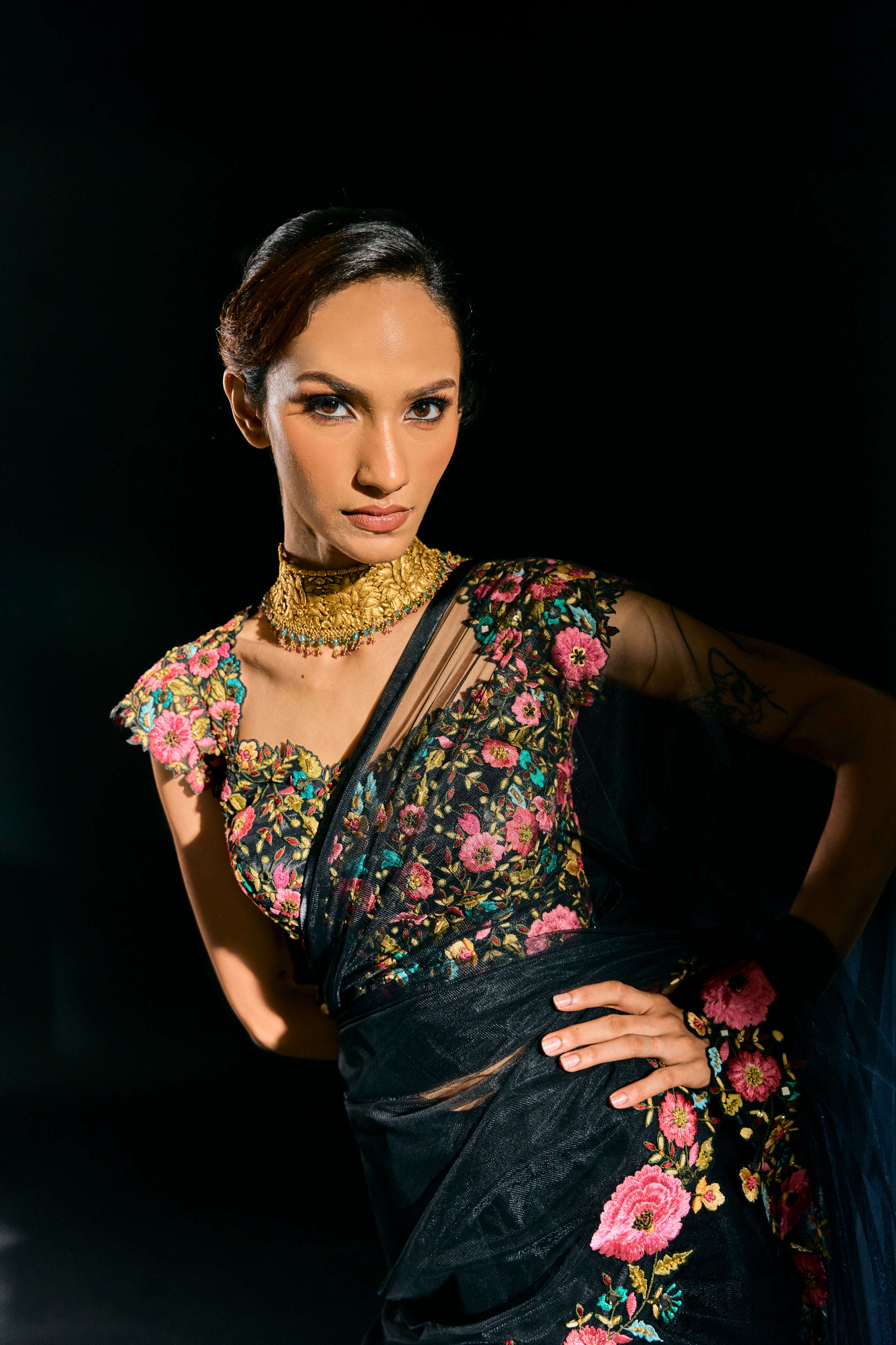 Model Esha Gohil posing in a closeup pic in black tulle drape and embroidered with floral resham that gleam like whispers in the dark. Handcrafted for "HAZE" - A/W'25 capsule collection by Archana Karthick.