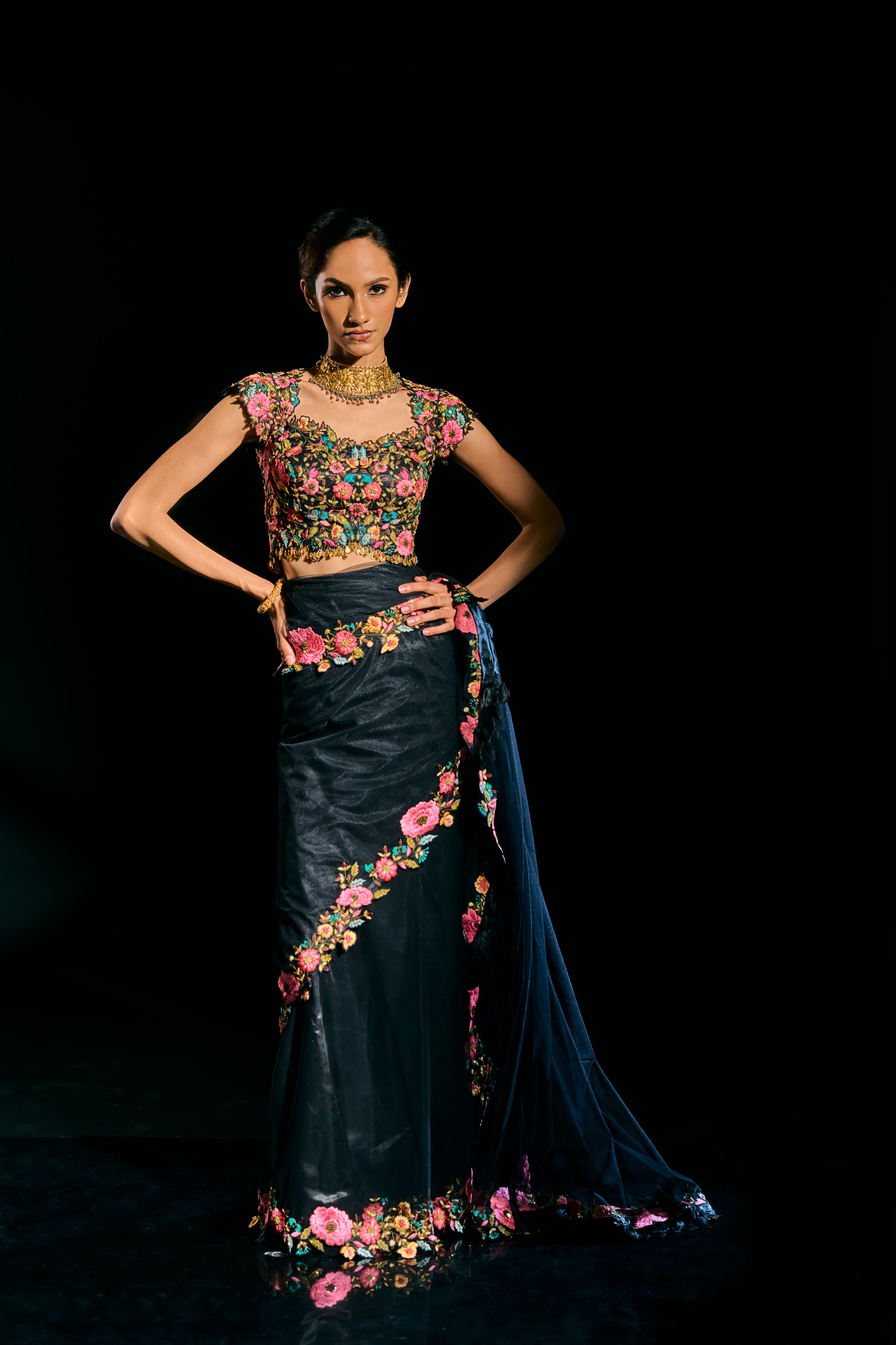 Model Esha Gohil posing straight in black tulle drape and embroidered with floral resham that gleam like whispers in the dark. Handcrafted for "HAZE" - A/W'25 capsule collection by Archana Karthick.