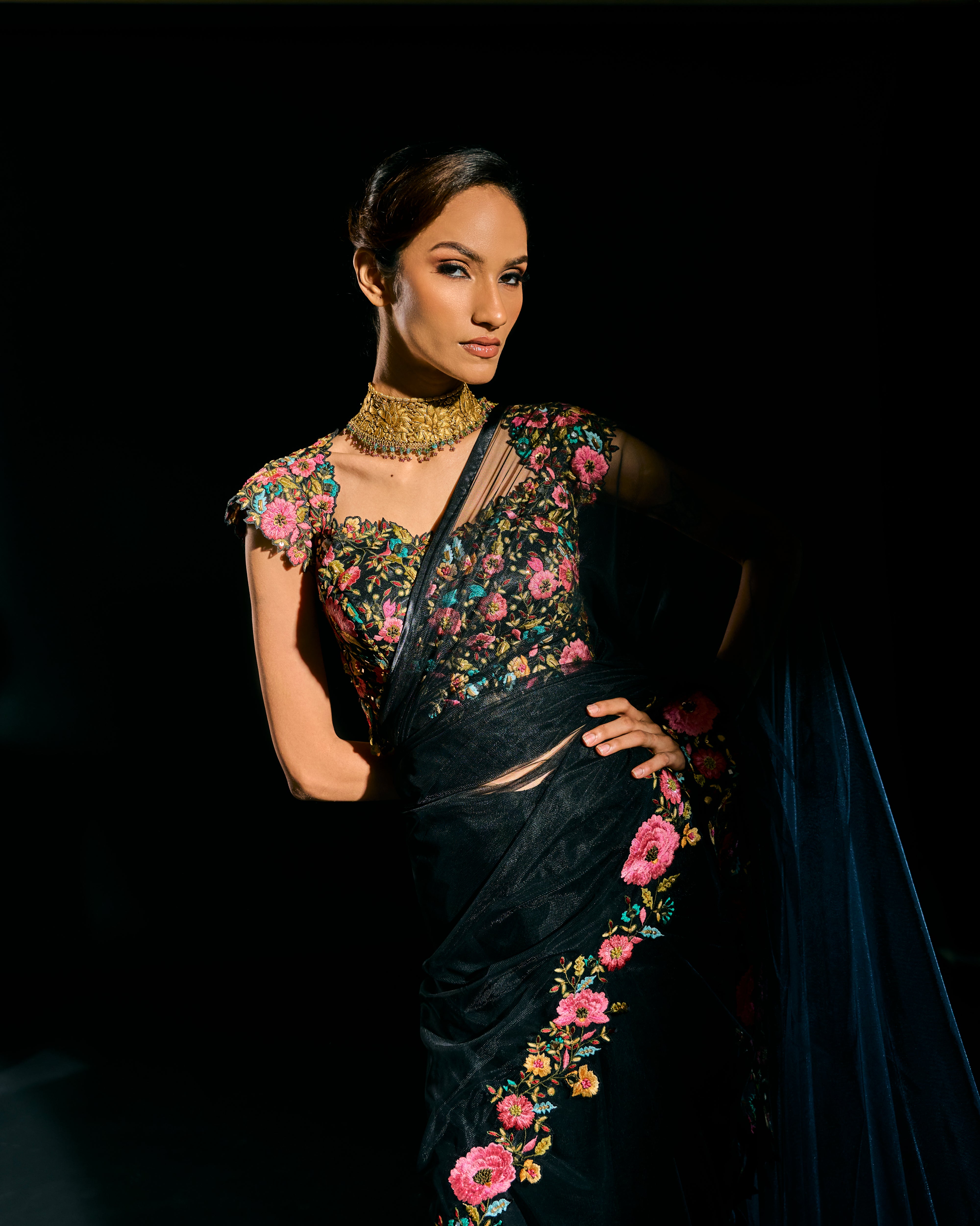 Model Esha Gohil showcasing blouse design in black tulle drape and embroidered with floral resham that gleam like whispers in the dark. Handcrafted for "HAZE" - A/W'25 capsule collection by Archana Karthick.