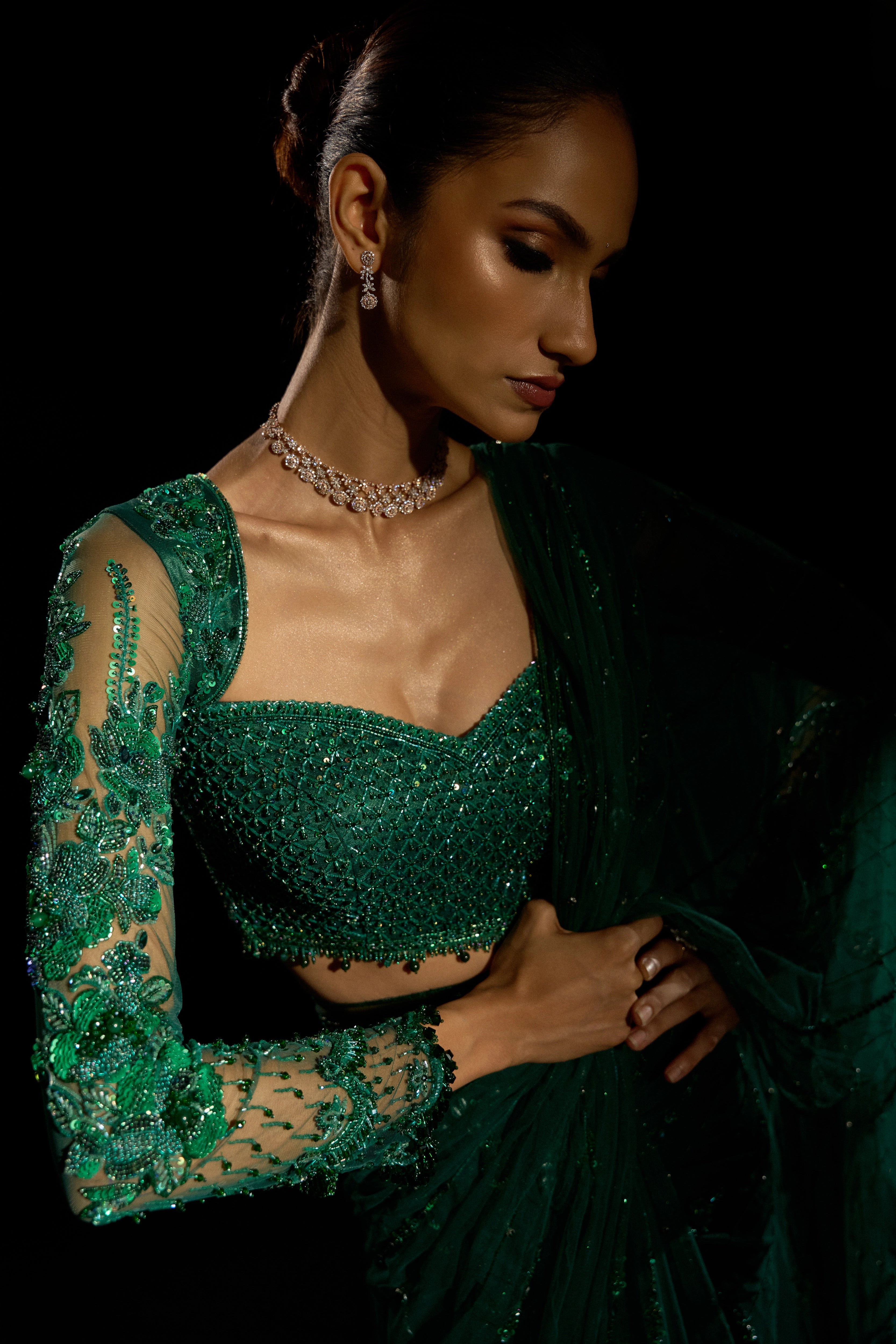 Model Esha Gohil showcasing sleeve design in a bottle green saree set is intricately adorned with sequins, rhinestones, crystals and cutdana for "STARDUST" - A/W'25 saree collection by team Archana Karthick.