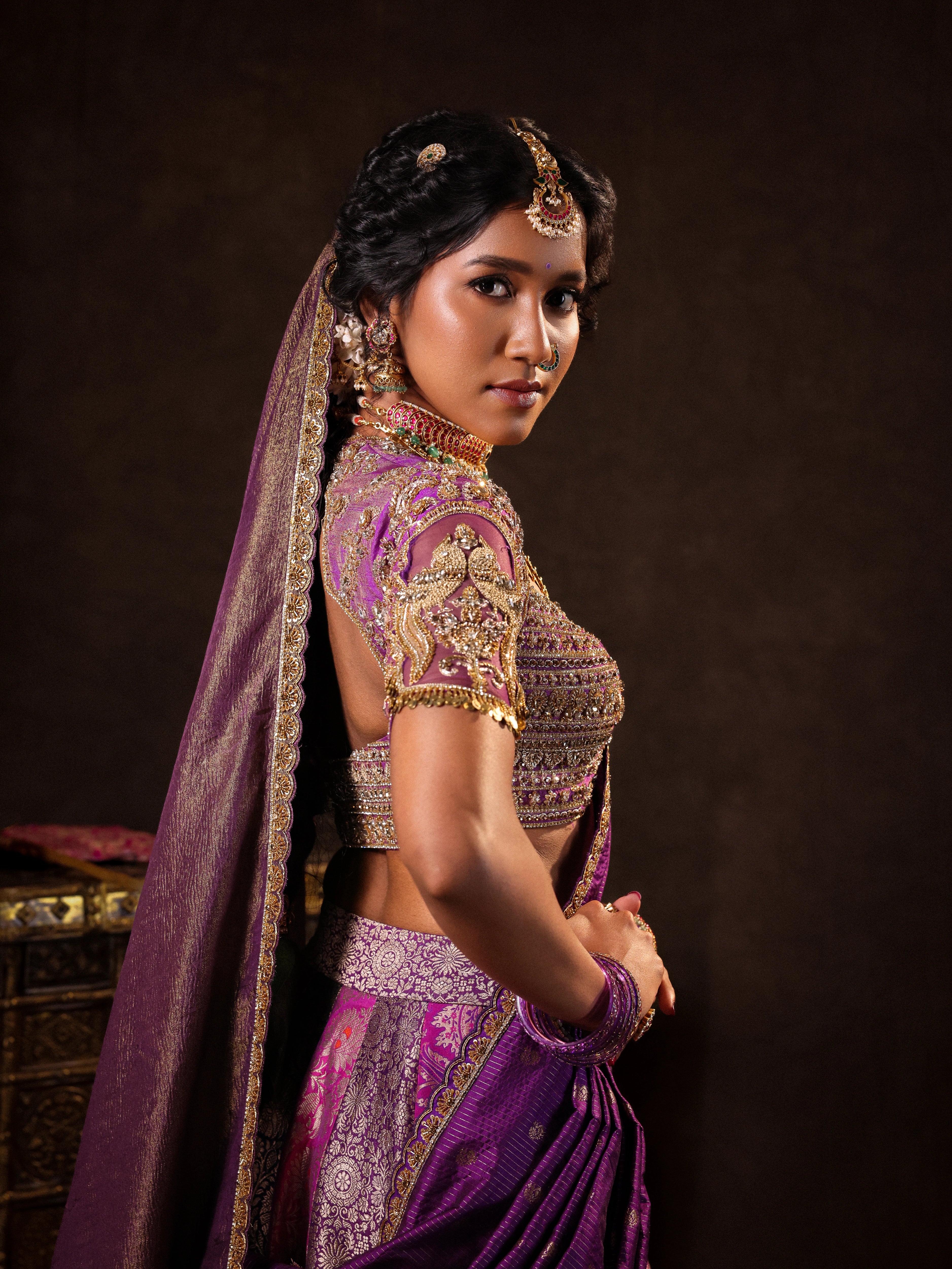 Model Gayathri Dhanasekar posing for detailings in a silk half saree in shades of purple with a scalloped veil is handrcrafted with sequins, cutdana, resham, stones and exquisite hangings by team Archana Karthick.