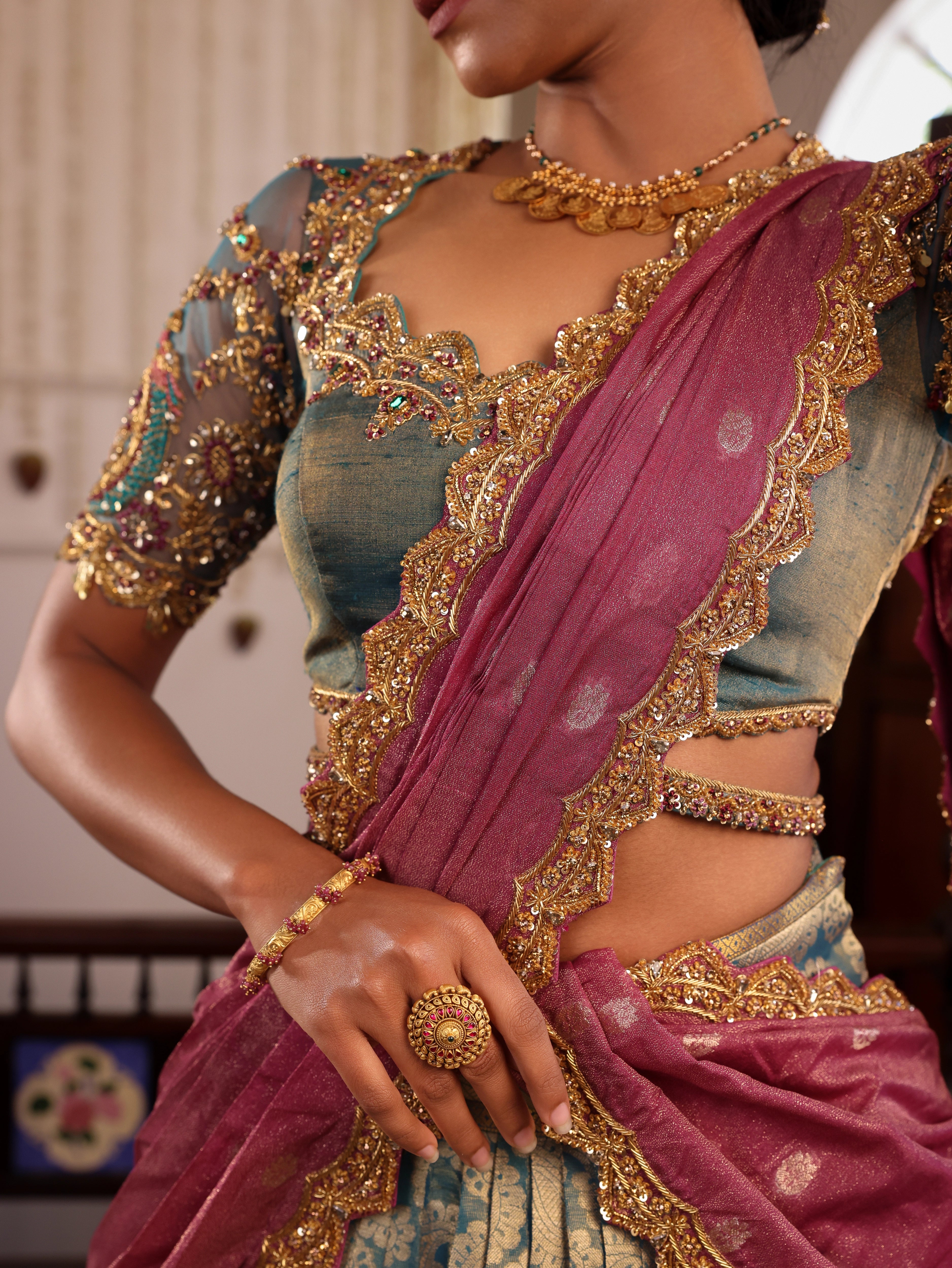 Model Gayathri Dhanasekar posing in a green silk half saree handcrafted by team Archana Karthick. Styled with jewelry sets from vummidi bangaru jewellers.