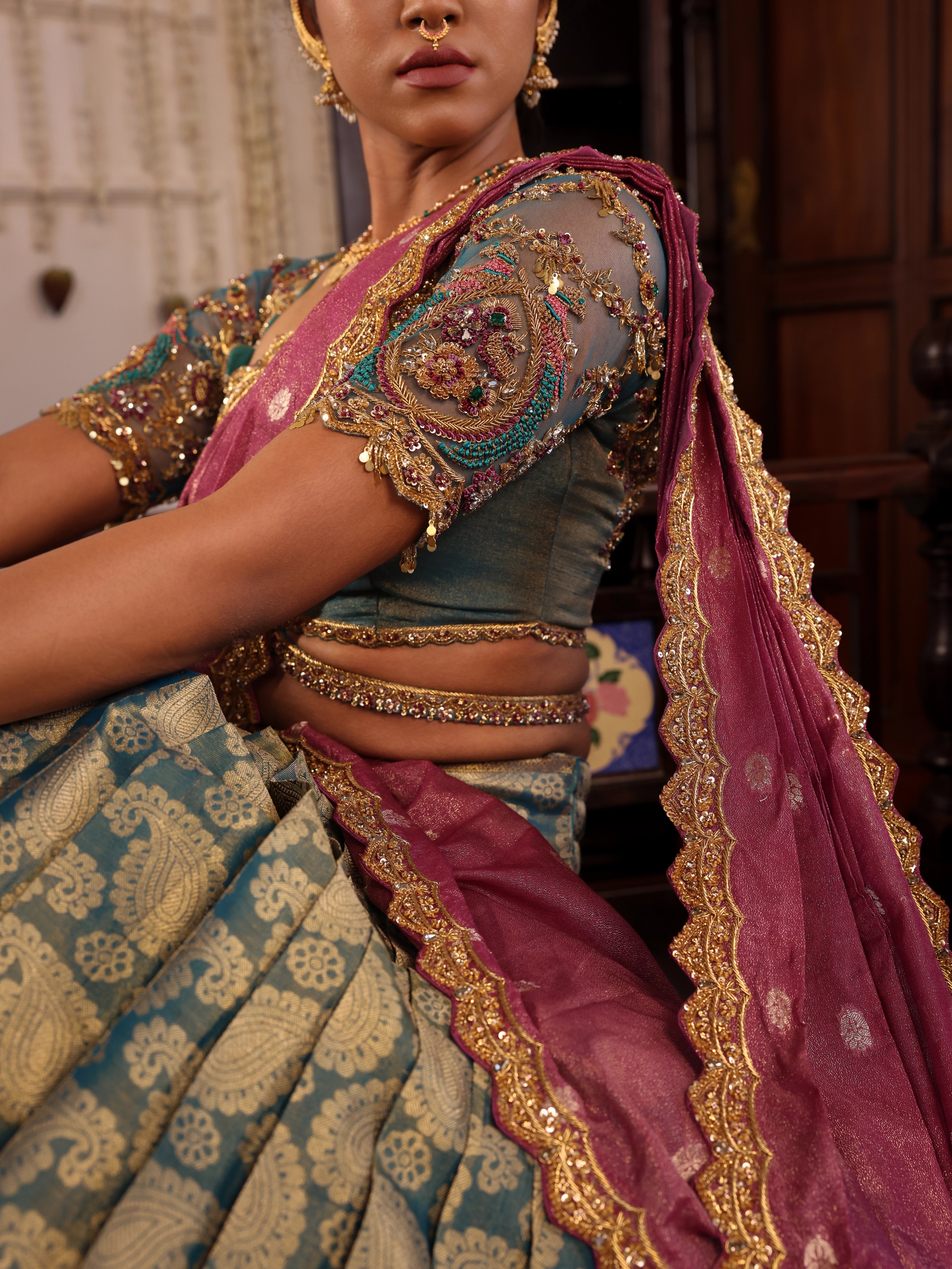 Model Gayathri Dhanasekar showcasing blouse and dupatta design in a green silk half saree handcrafted by team Archana Karthick. Styled with jewelry sets from vummidi bangaru jewellers.