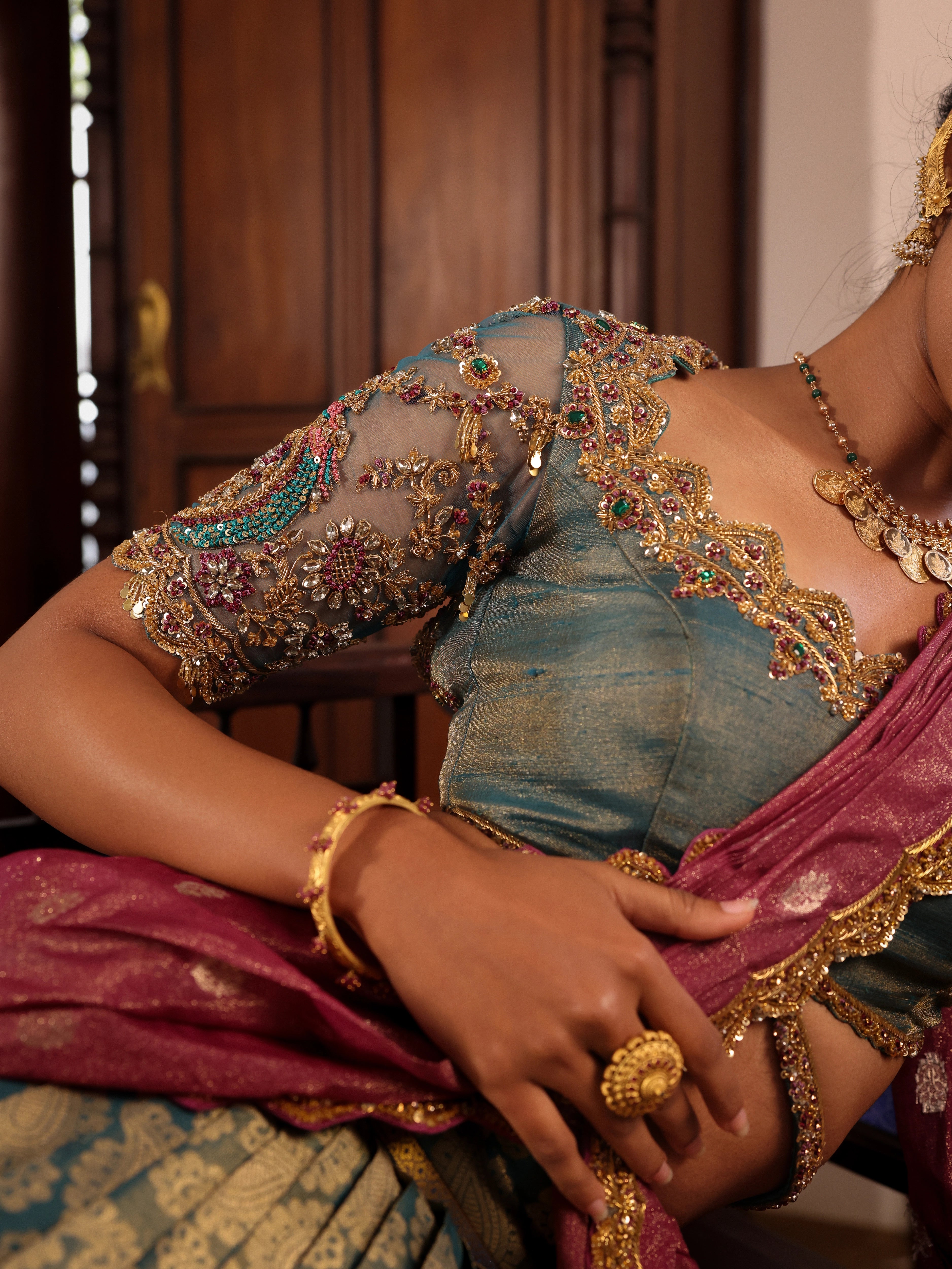 Model Gayathri Dhanasekar showcasing blouse neck design in a green silk half saree handcrafted by team Archana Karthick. Styled with jewelry sets from vummidi bangaru jewellers.