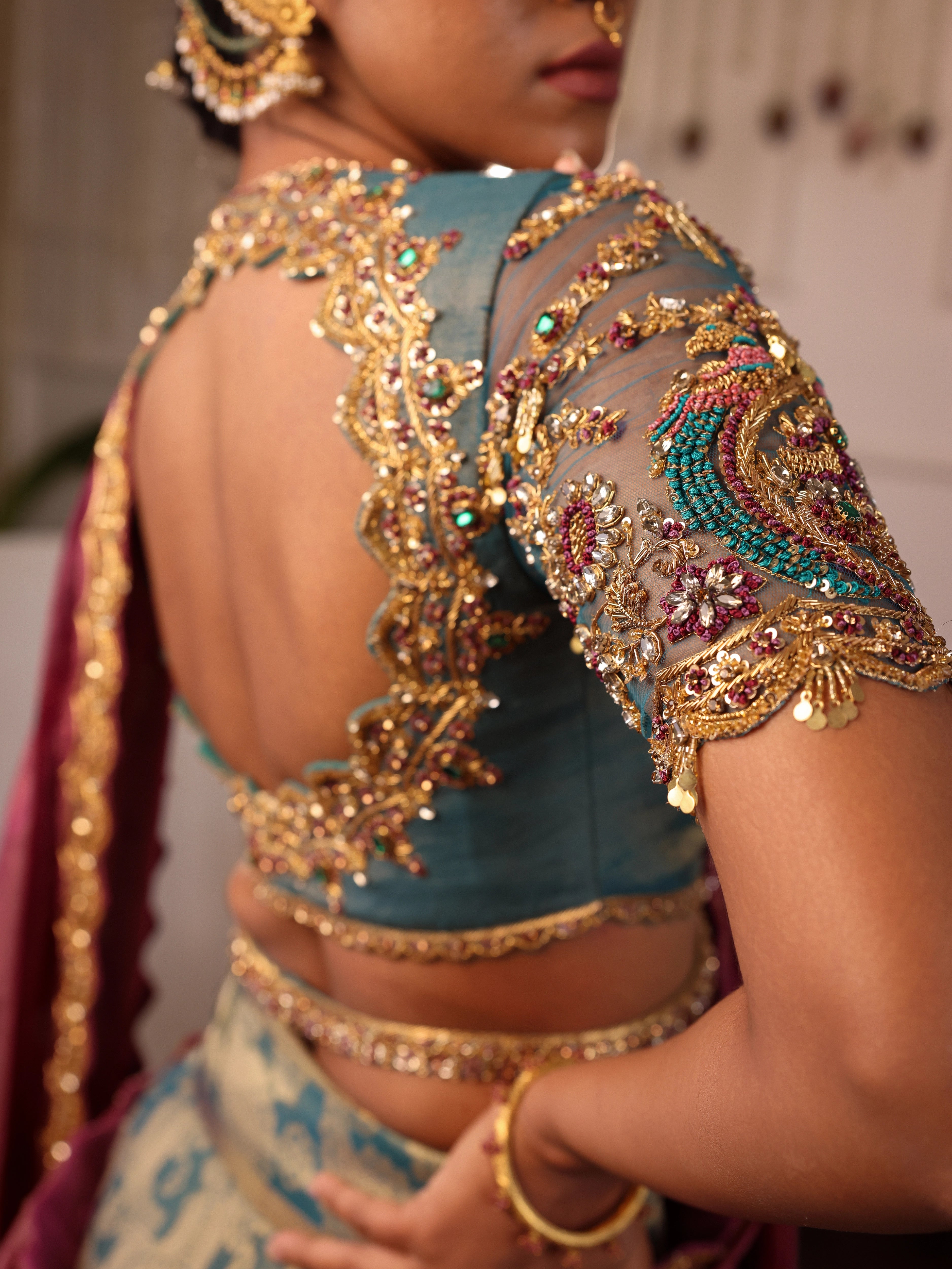 Model Gayathri Dhanasekar showcasing blouse sleeve and blouse back design in a green silk half saree handcrafted by team Archana Karthick. Styled with jewelry sets from vummidi bangaru jewellers.