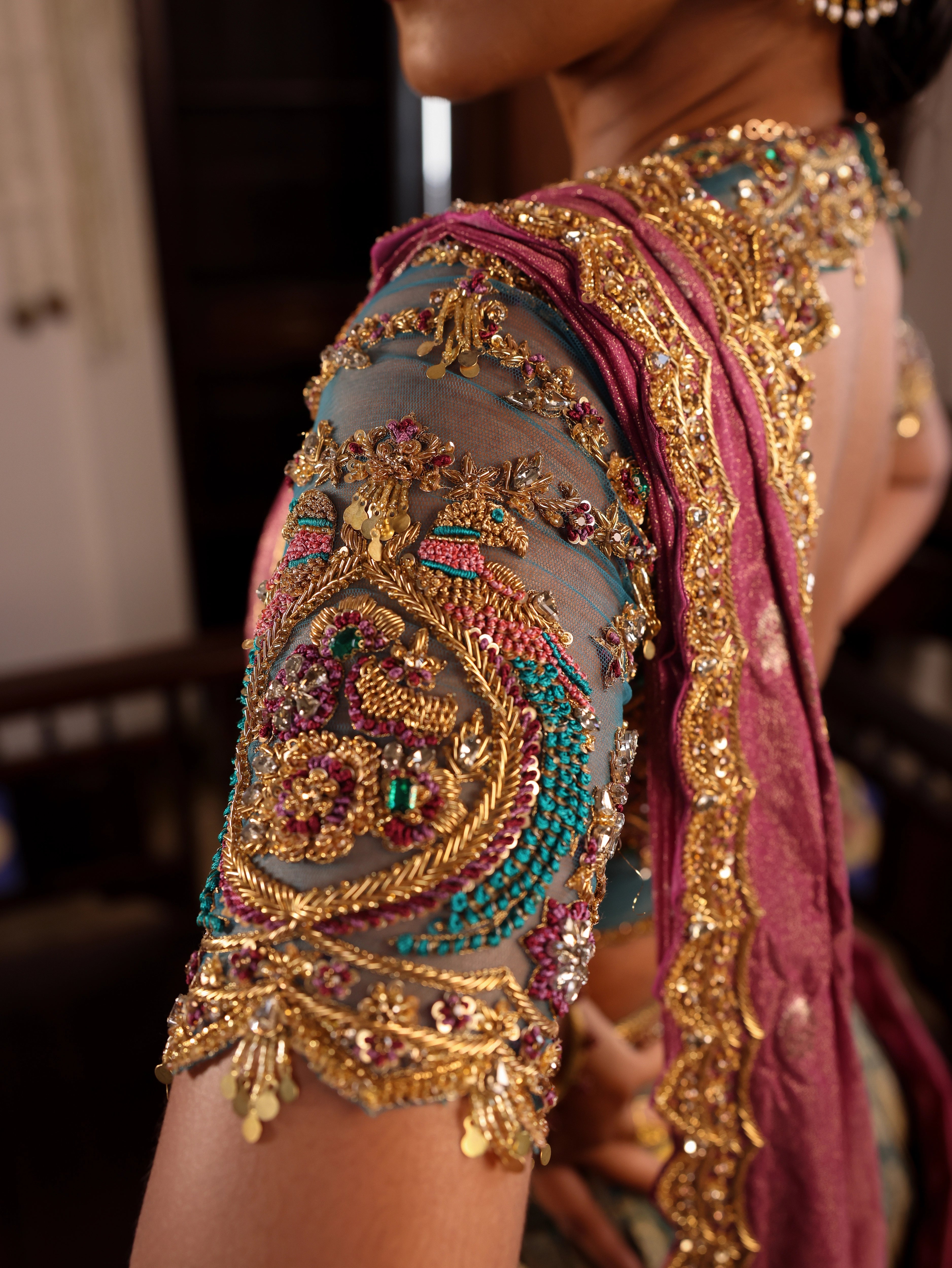 Model Gayathri Dhanasekar showcasing blouse sleeve in a green silk half saree handcrafted by team Archana Karthick. Styled with jewelry sets from vummidi bangaru jewellers.