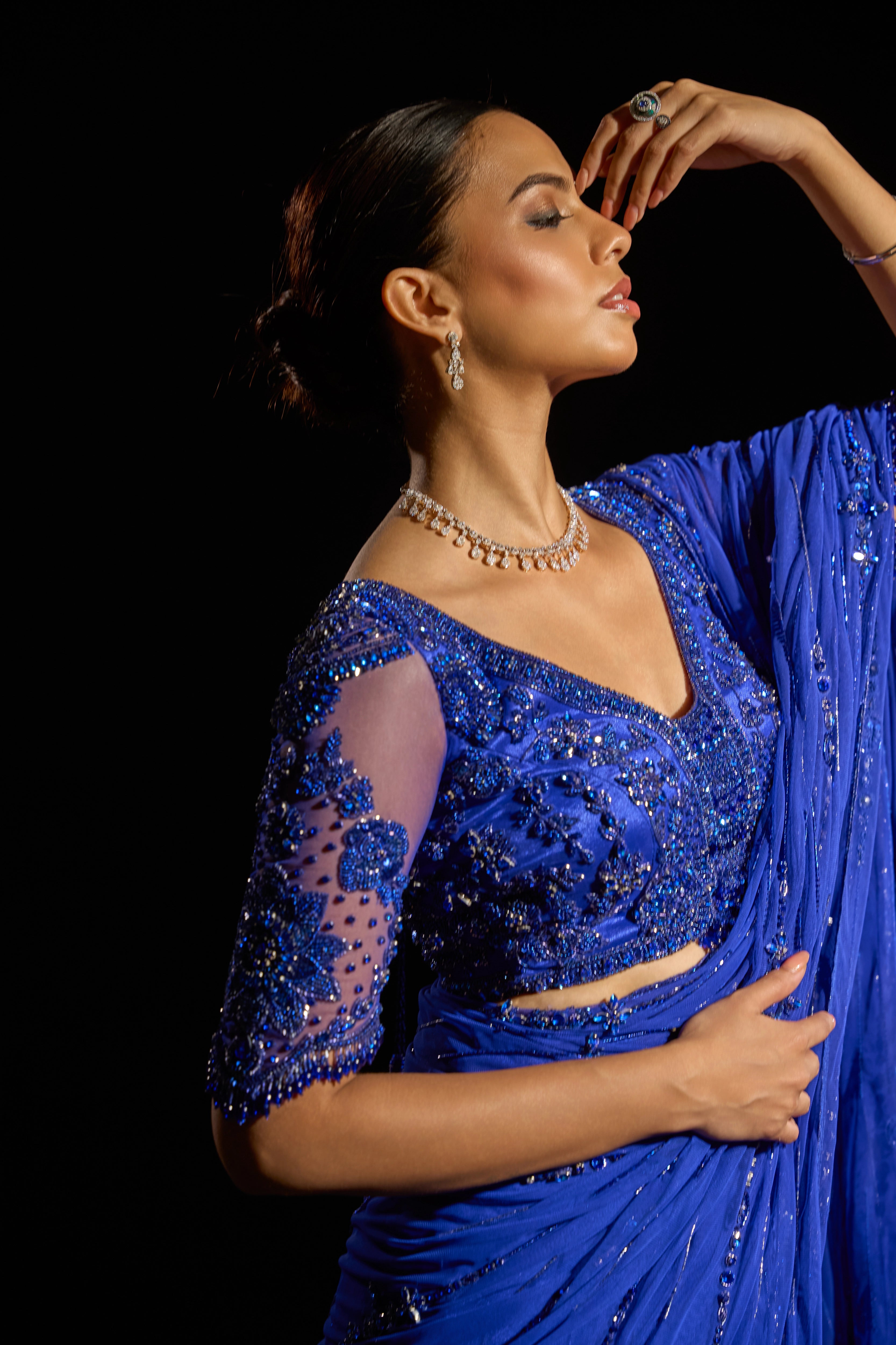 Model Jane C Thompson posing for photoshoot in a sapphire blue saree set intricately adorned with sequins, rhinestones, crystals and cutdana for "STARDUST" - A/W'25 saree collection by team Archana Karthick.