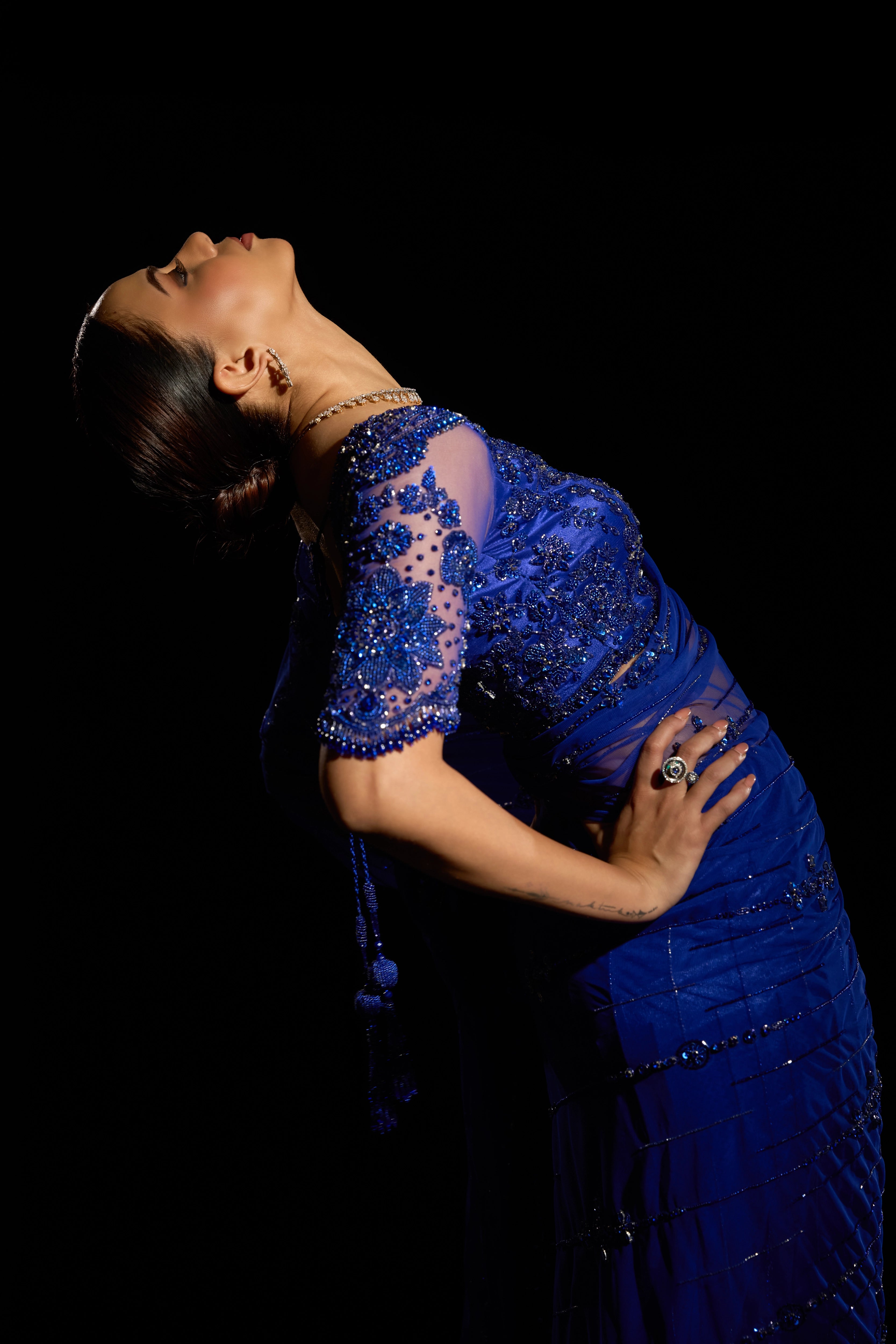 Model Jane C Thompson posing in a sapphire blue saree set intricately adorned with sequins, rhinestones, crystals and cutdana for "STARDUST" - A/W'25 saree collection by team Archana Karthick.
