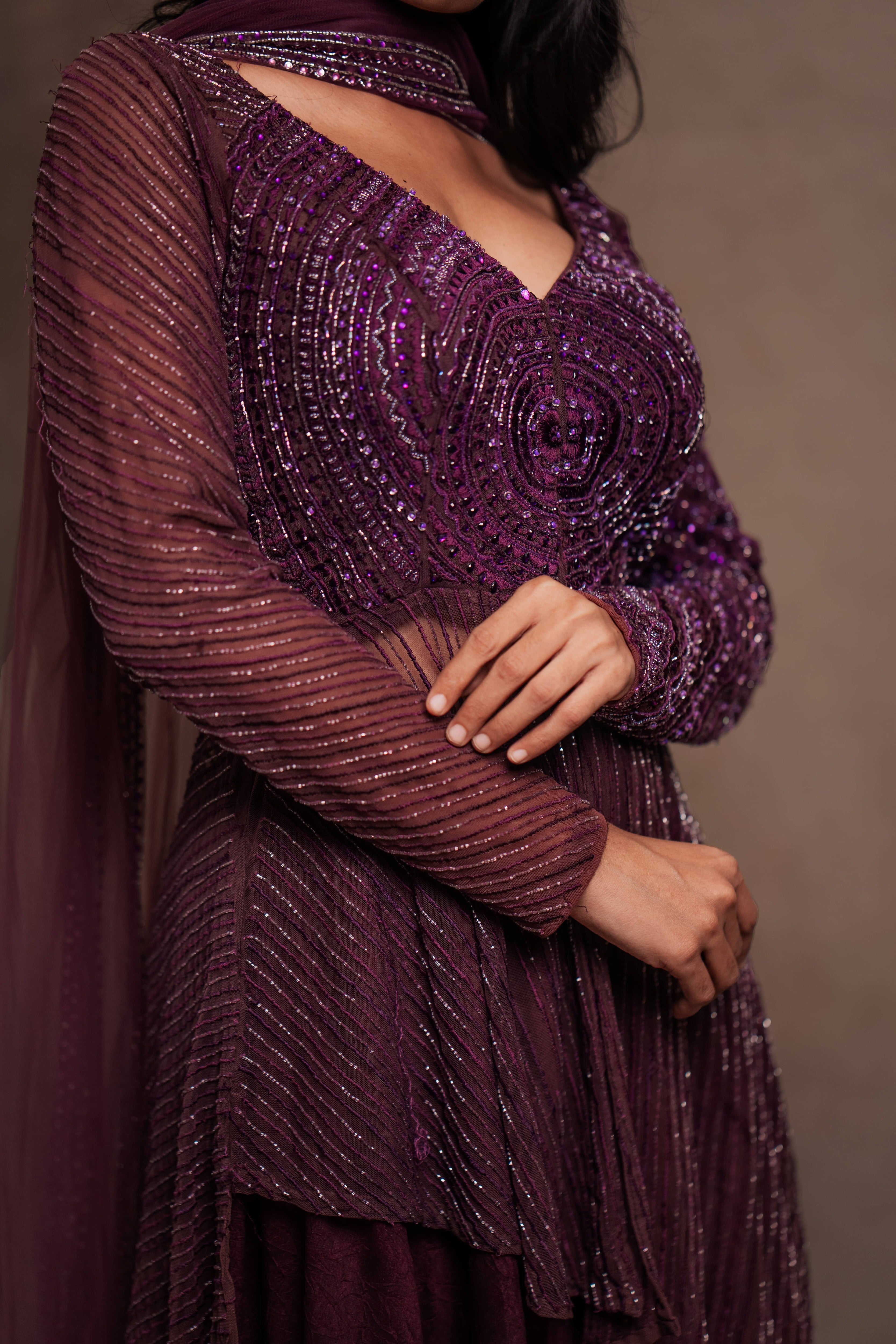 Model Premika Sekar in aubergine peplum sharara posing for closeup design capture