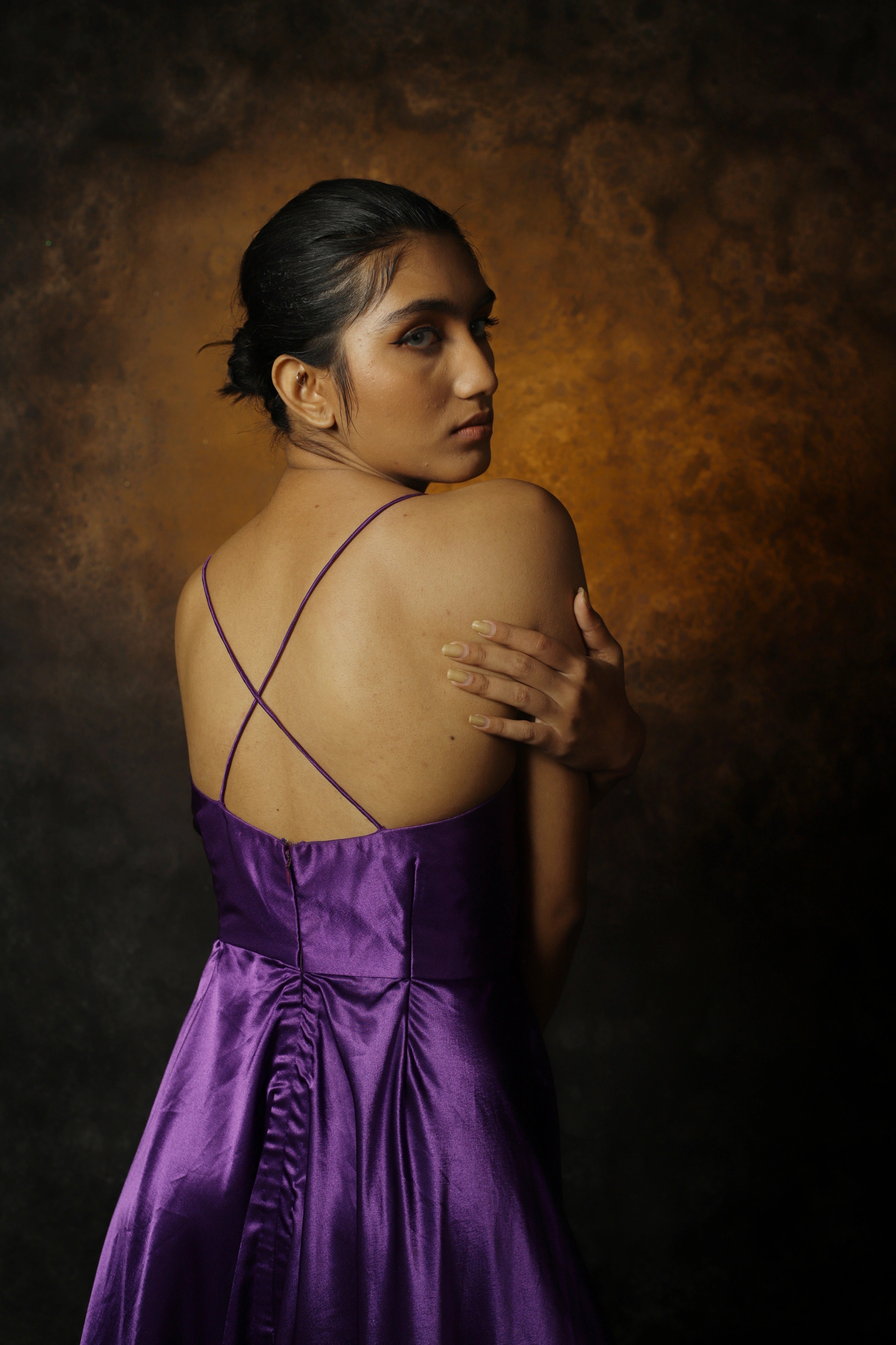 Model Rali Alph posing for photo in a sleeveless violet satin slip dress by team Archana Karthick.