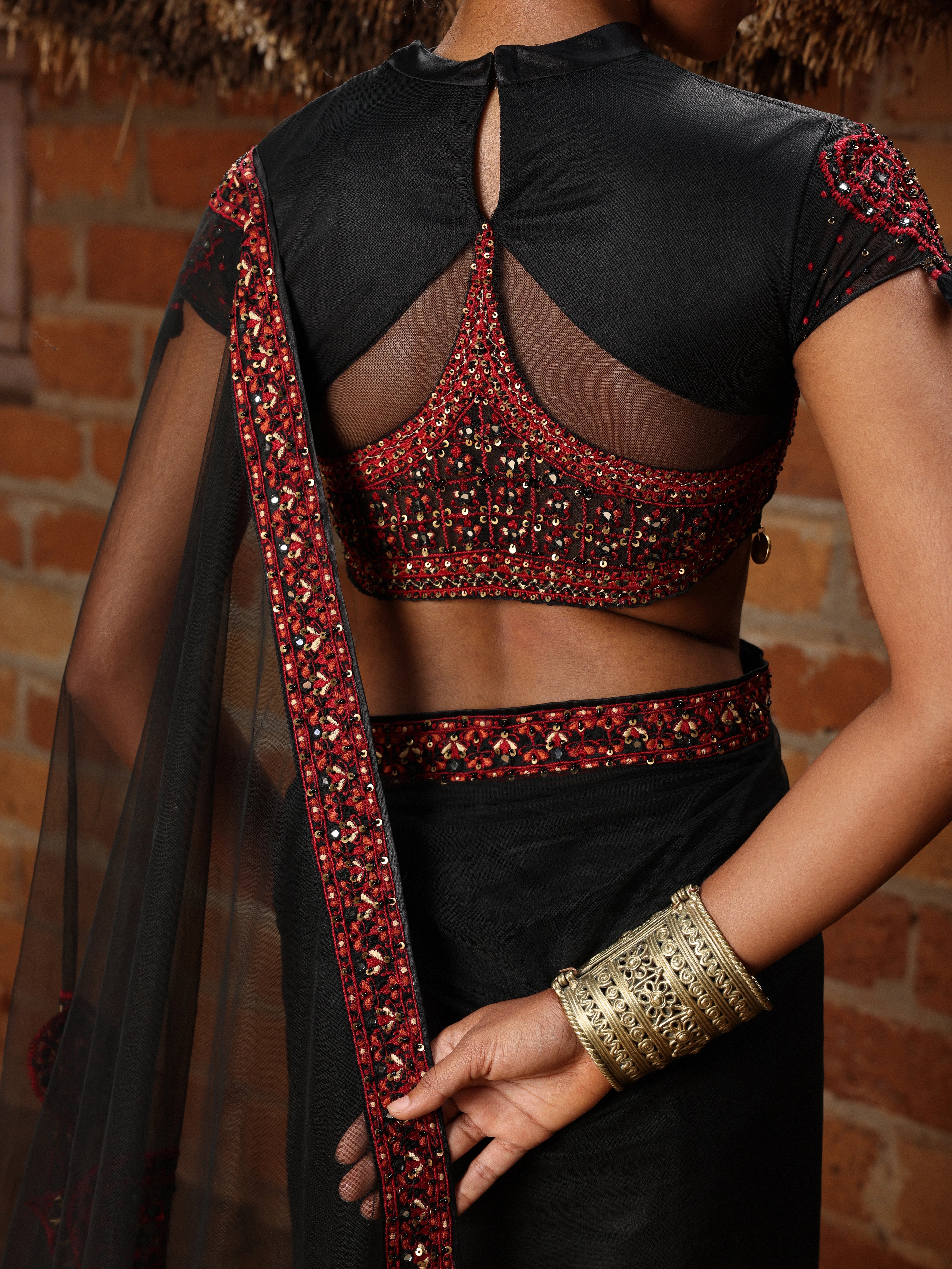 Model in black and red net saree with blouse.