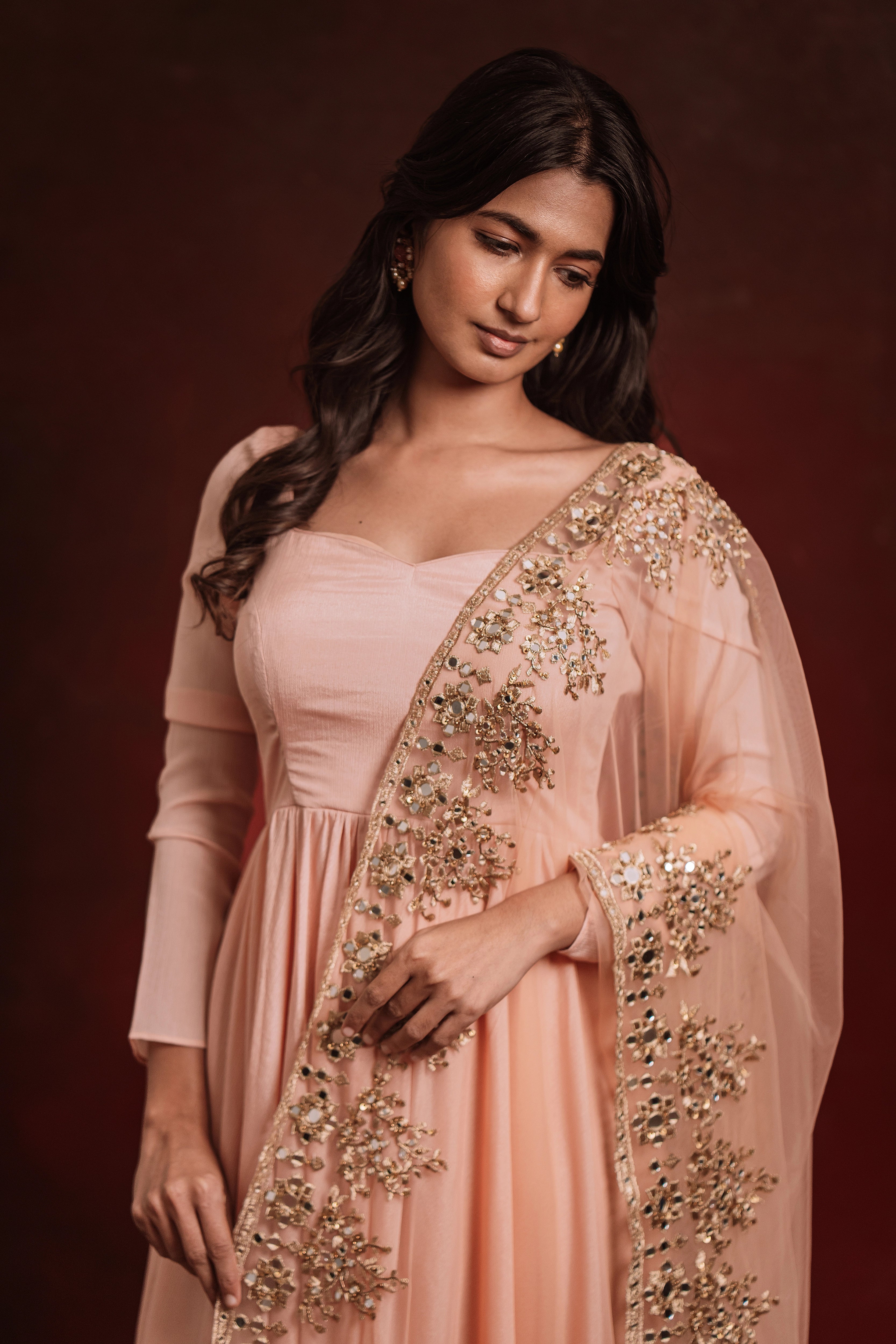 Model smiling in "Mellow Peach", a georgette anarkali paired with a handcrafted tulle dupatta, for a festive look, while keeping the trend intact.