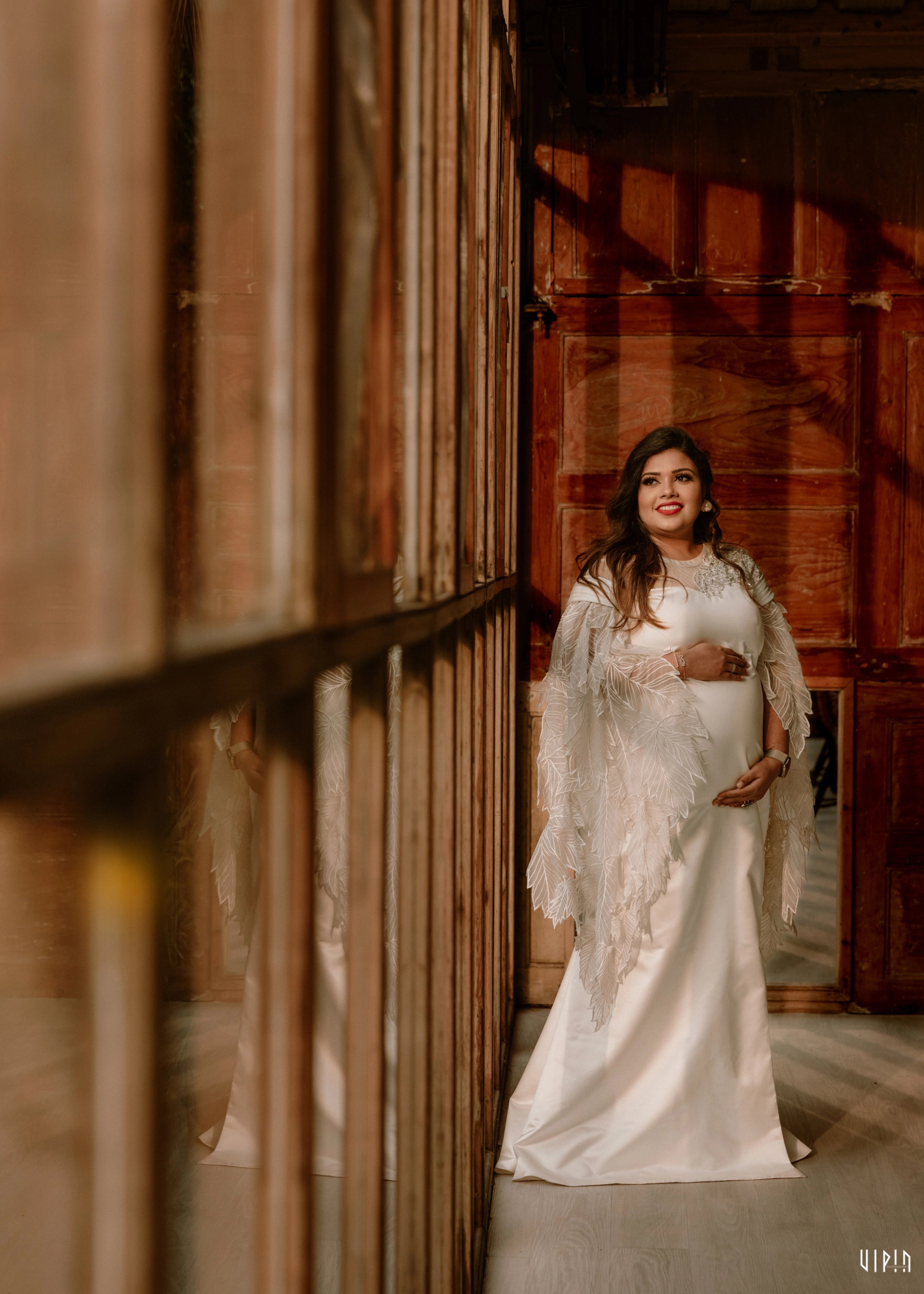 Mom to be Dr Nishitha in a white satin maternity gown, with leaf applique detailings by team Archana Karthick.