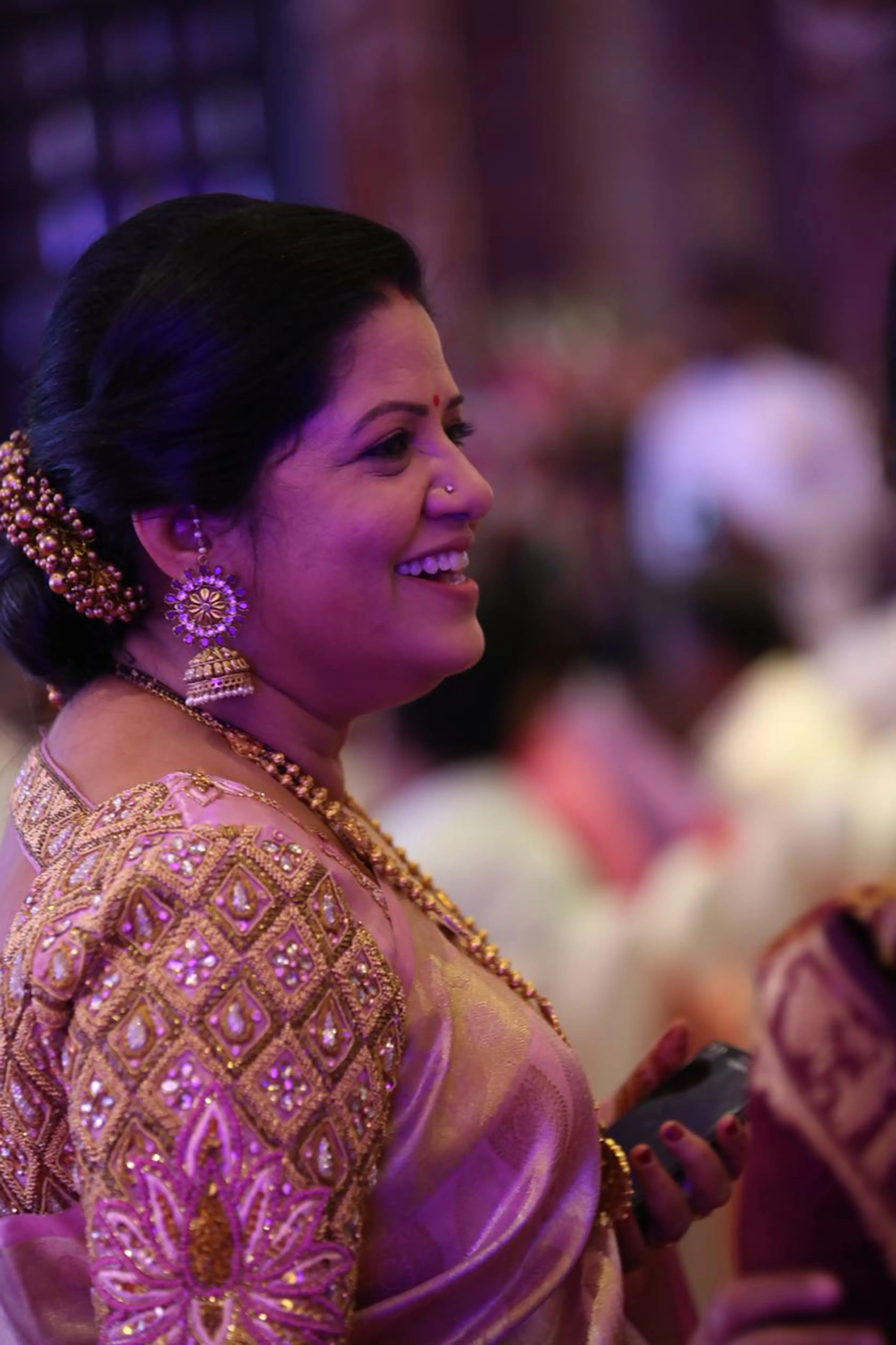Mother of the bride smiling in a pink silk blouse, handcrafted by team Archana Karthick.