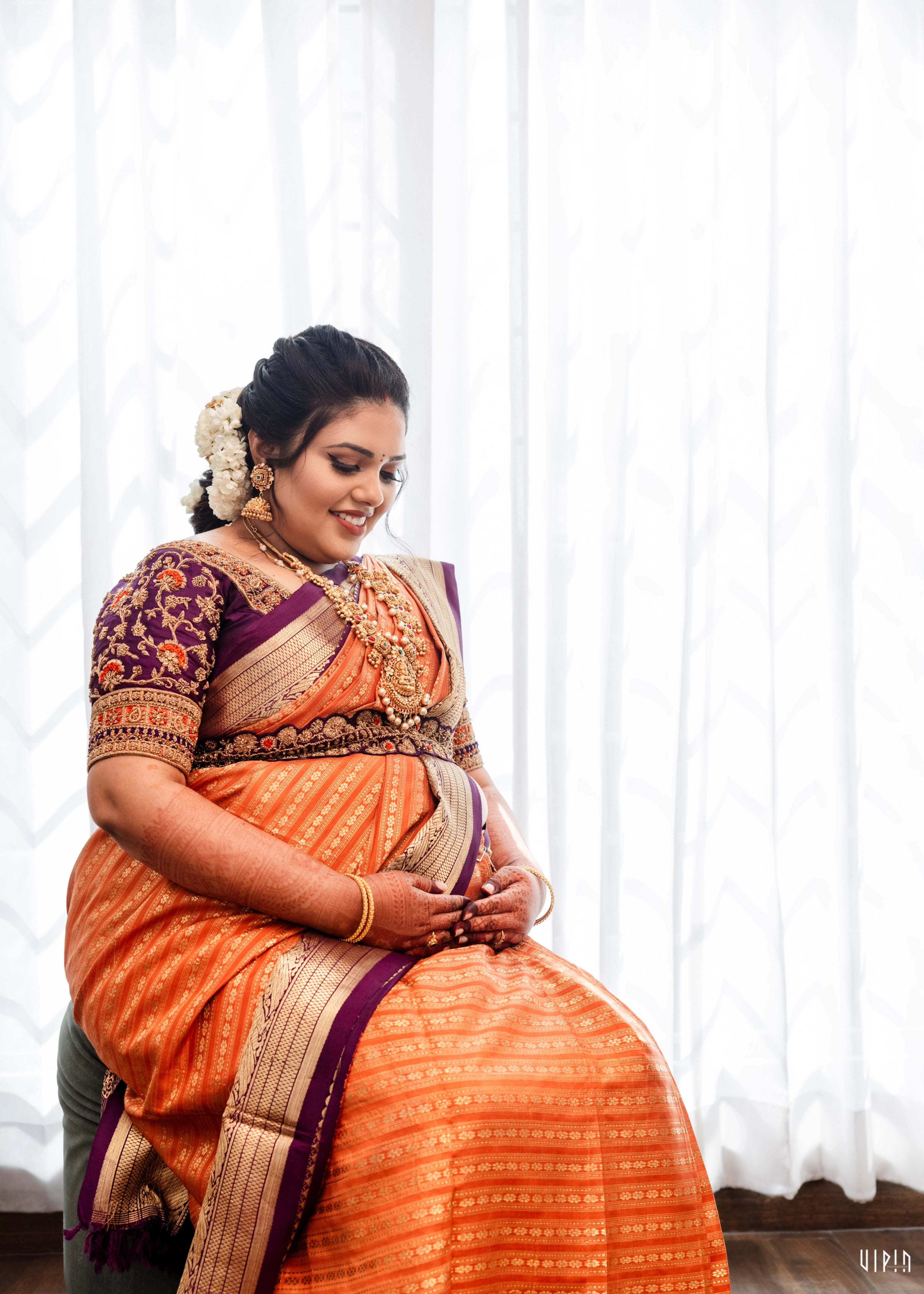 Mother to be, Dr Nishitha posing in a purple silk blouse handcrafted by team Archana Karthick.