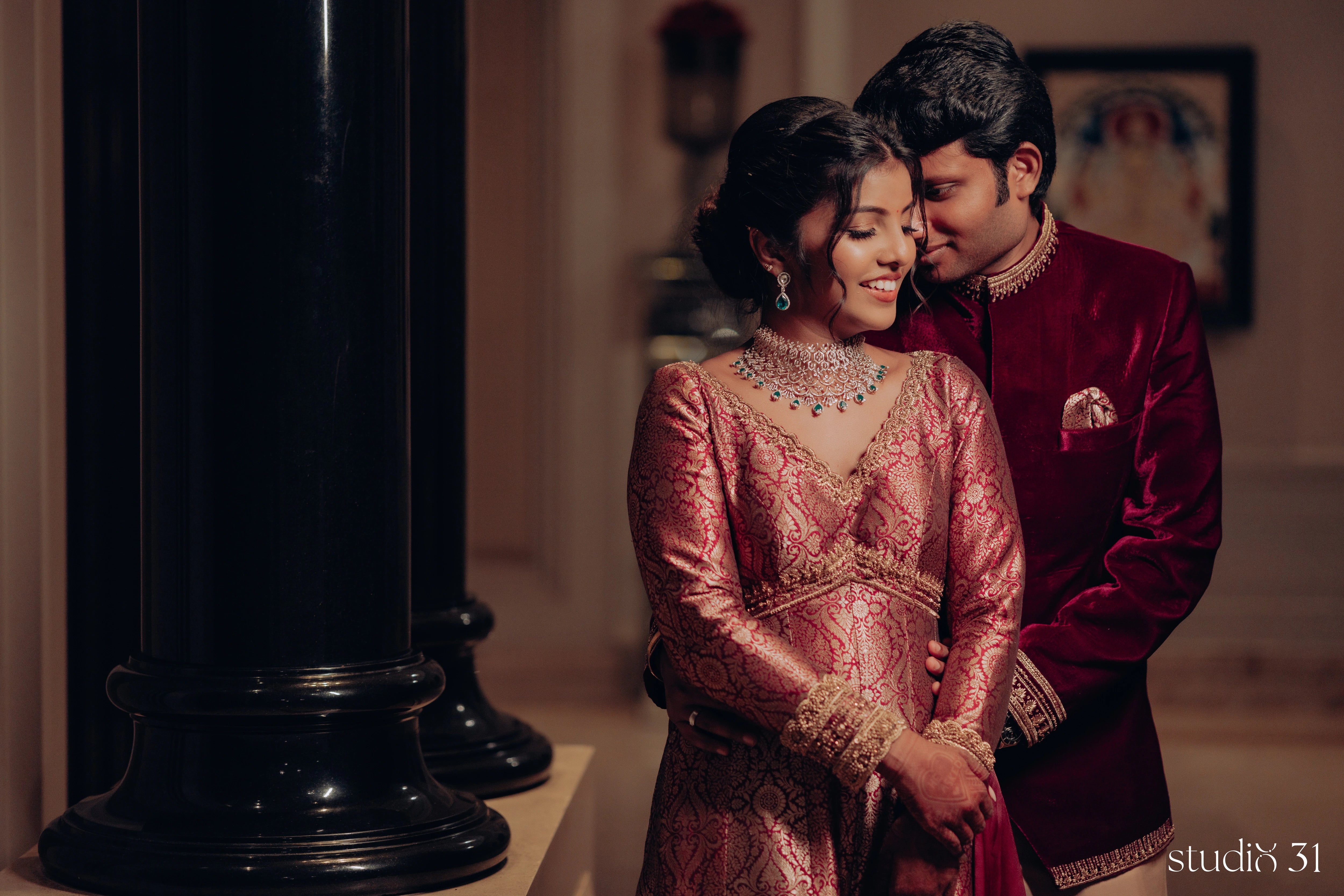 Pooja & Rhevanth posing for their engagement in a maroon ensemble by Archana Karthick