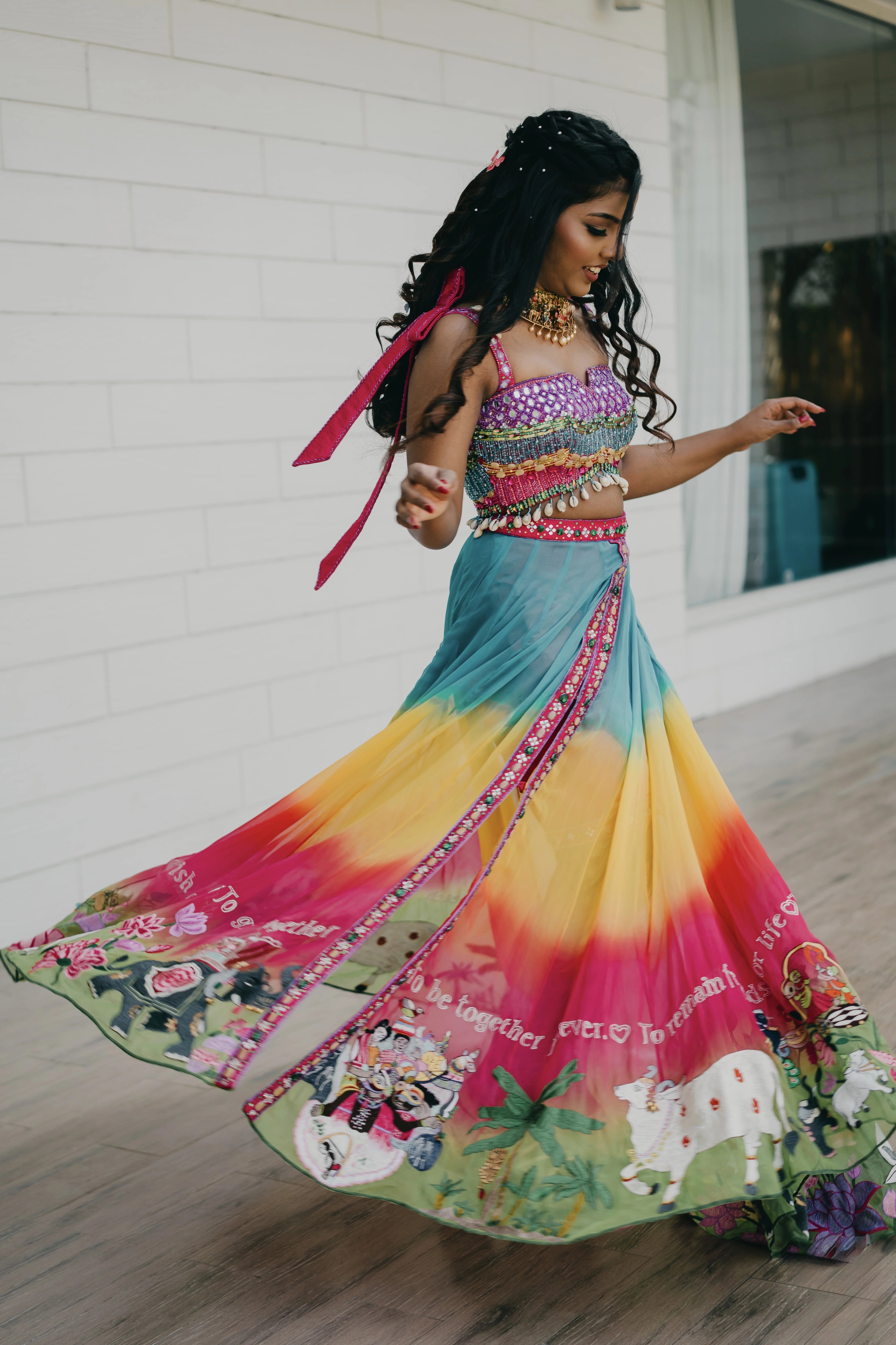 Pooja twirling in a multi-colored fusion lehenga for her mehendi, dyed and intricately handcrafted by team Archana Karthick.