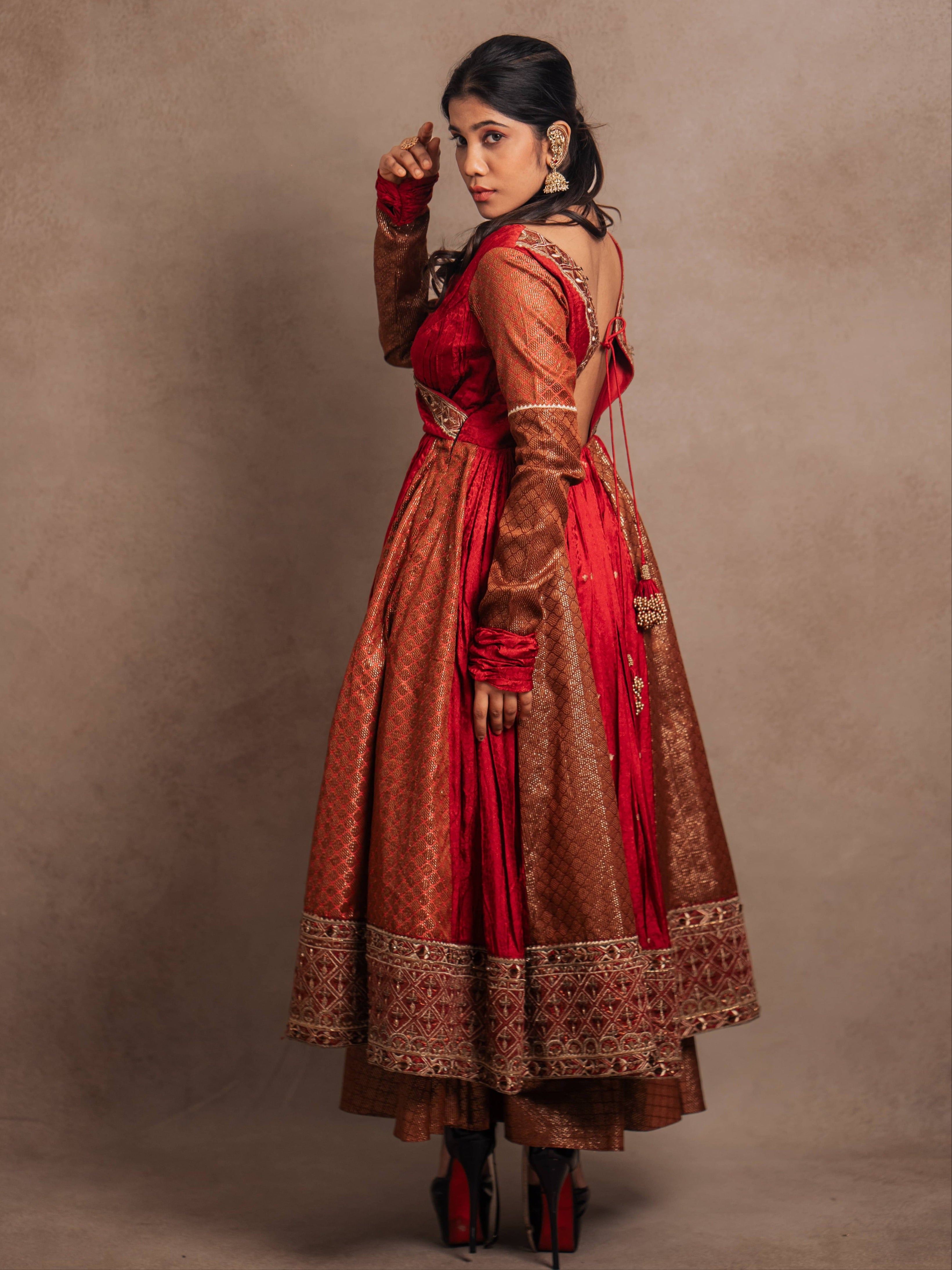 Side design details of a Red-orange angrakha anarkali in banarasi tissue and silk paired with a sharara pant and a delicate tissue dupatta by team Archana Karthick