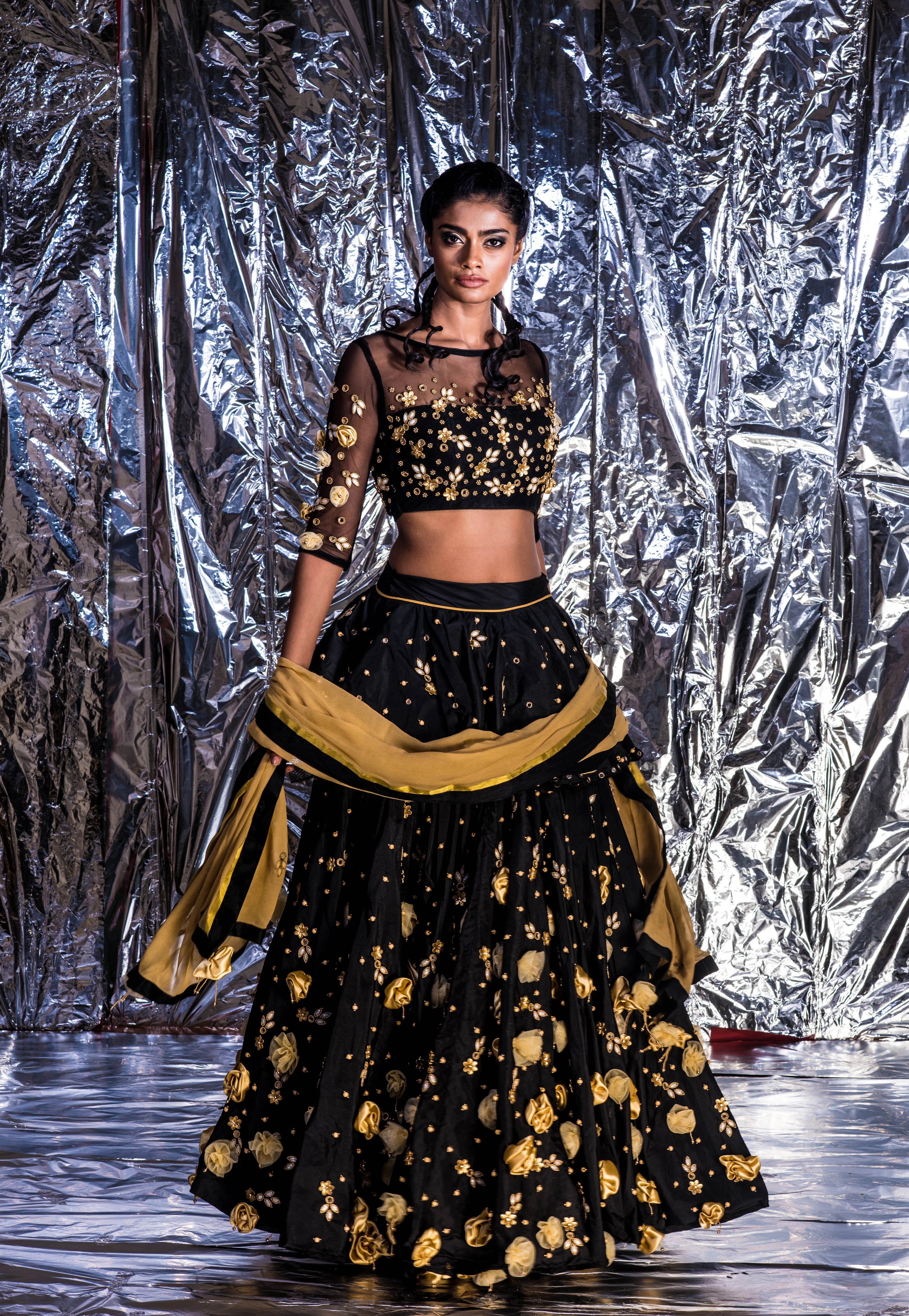 Supermodel Archana Akil Kumar in a black taffeta lehenga with a gold georgette dupatta intricately handcrafted with appliques, pearls, mirror and beads.