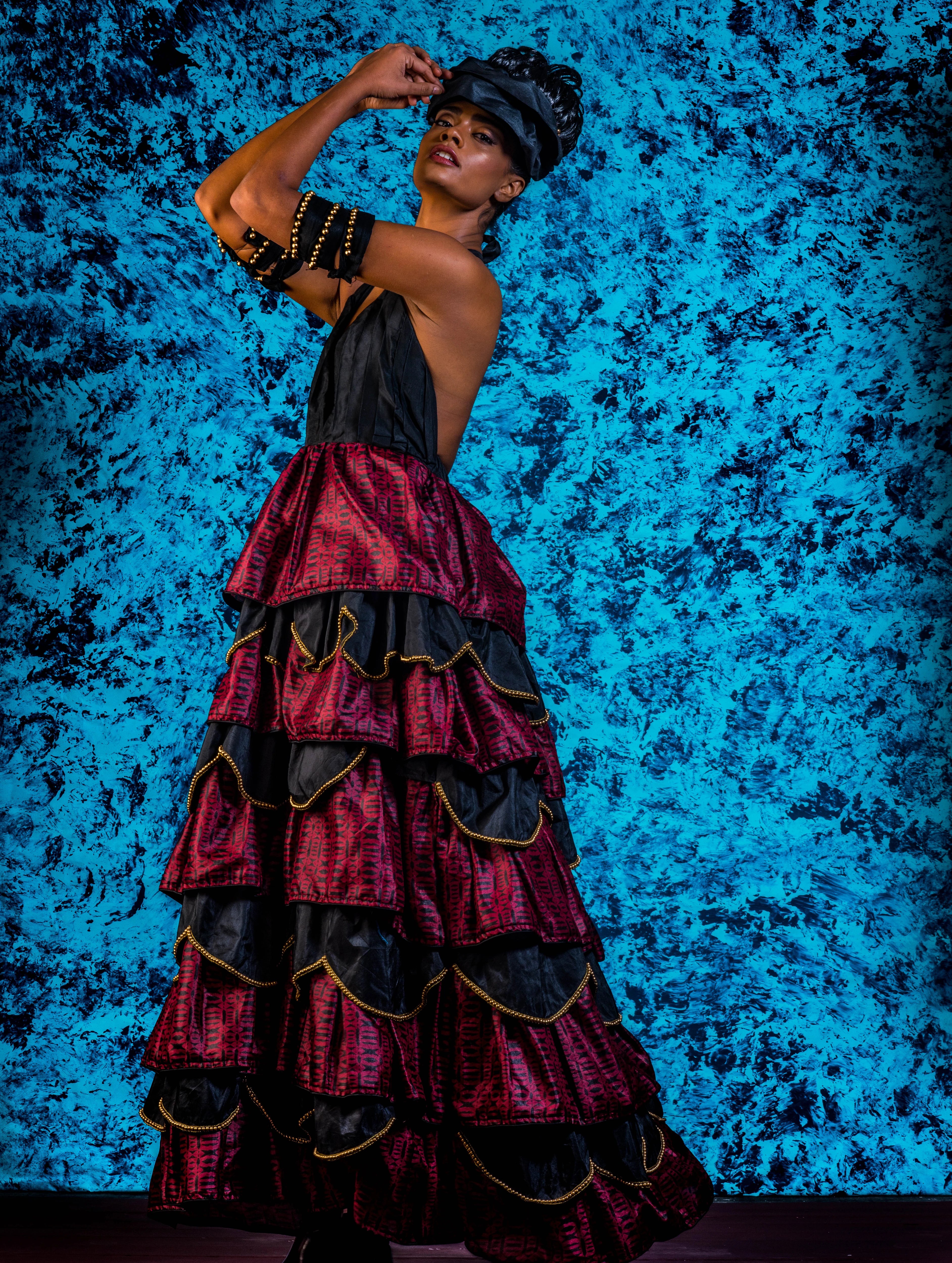 Supermodel Archana Akil Kumar posing for side profile a noir halterneck gown with a multi-tiered scalloped look. Partywear Gown.