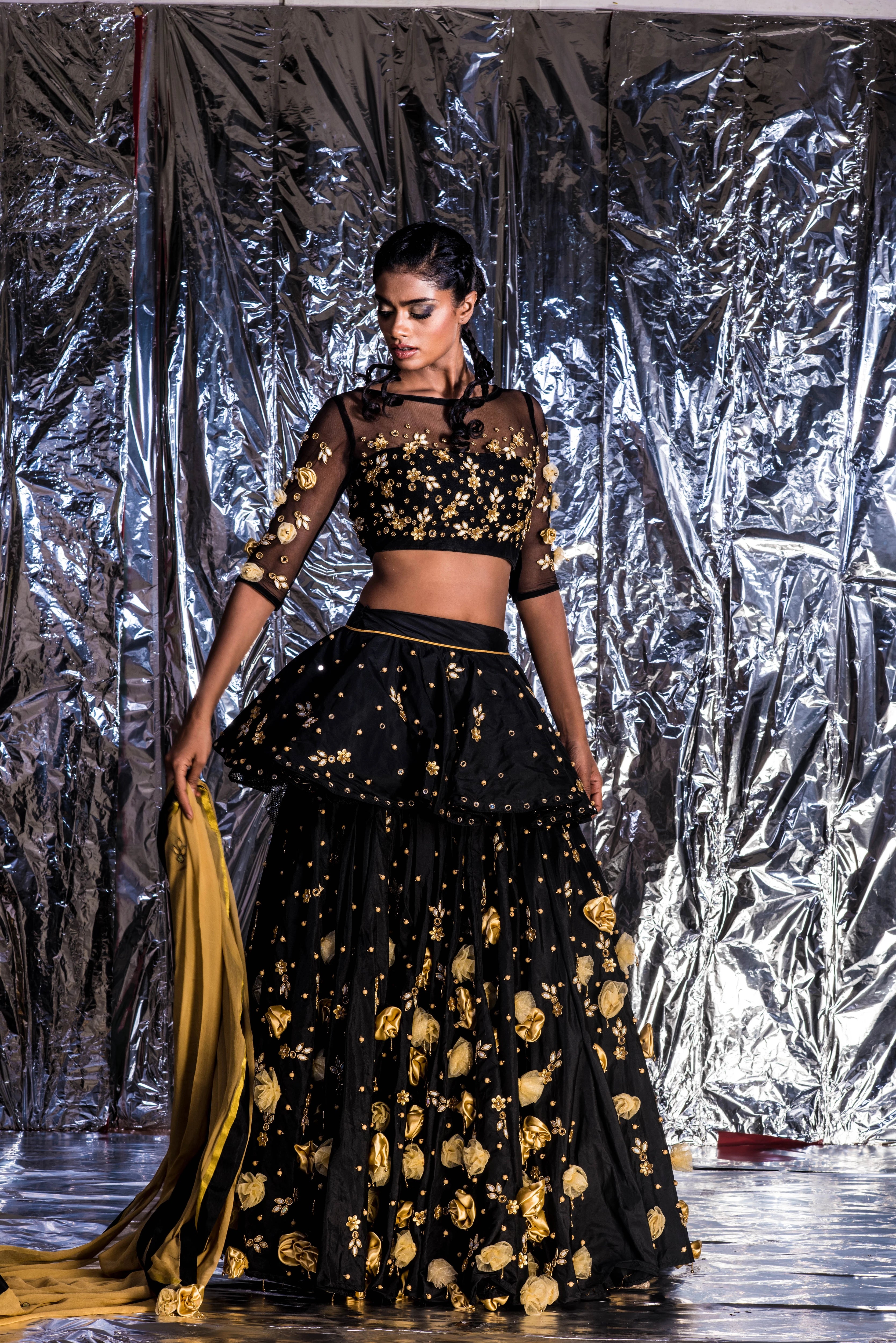 Supermodel Archana Akil Kumar posing without dupatta in a black taffeta lehenga with a gold georgette dupatta intricately handcrafted with appliques, pearls, mirror and beads.