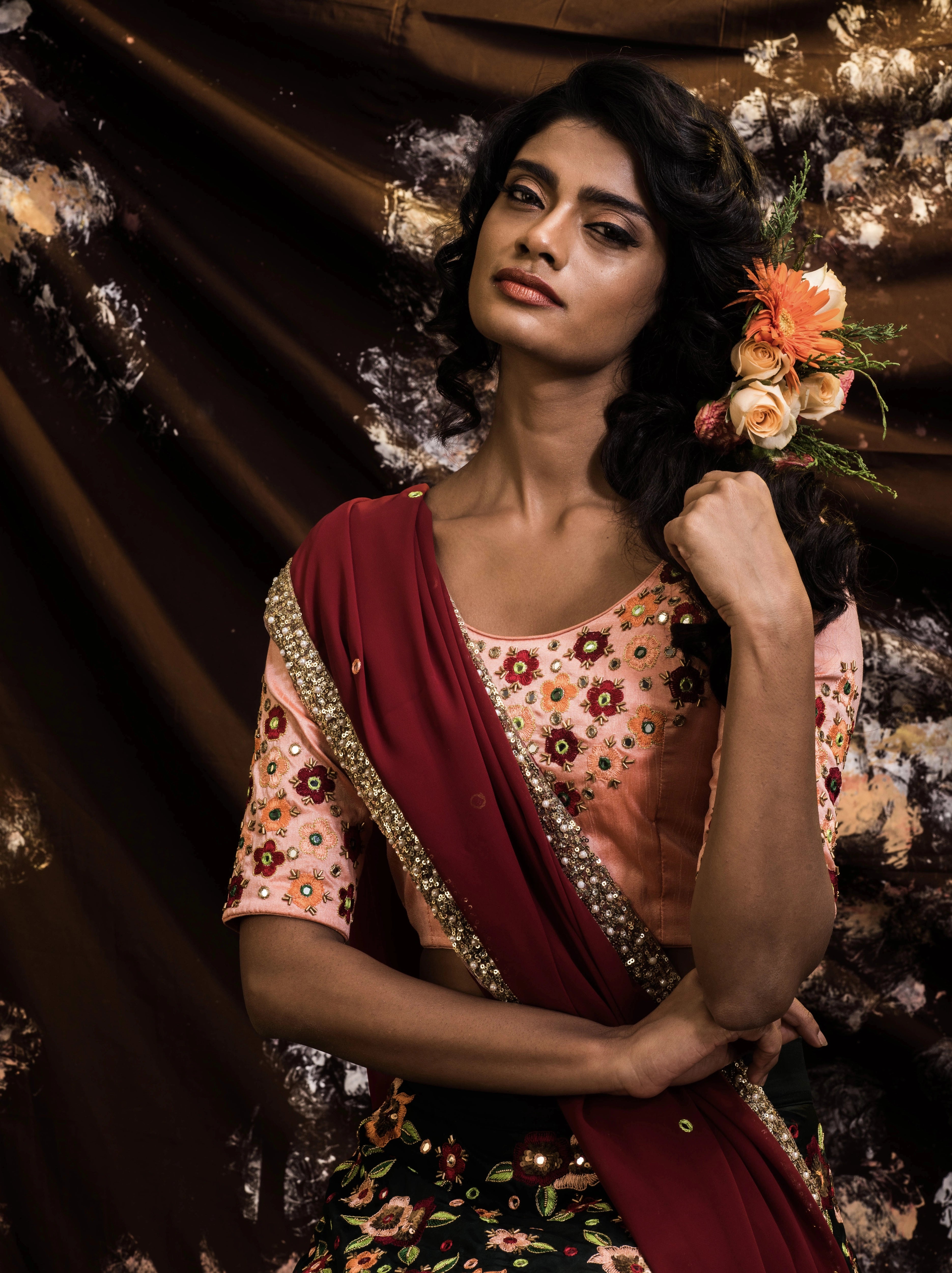 Supermodel Archana Akil Kumar showcasing blouse detailings in a rawsilk peach and bottle green lehenga with a maroon georgette dupatta intricately handcrafted by team Archana Karthick.