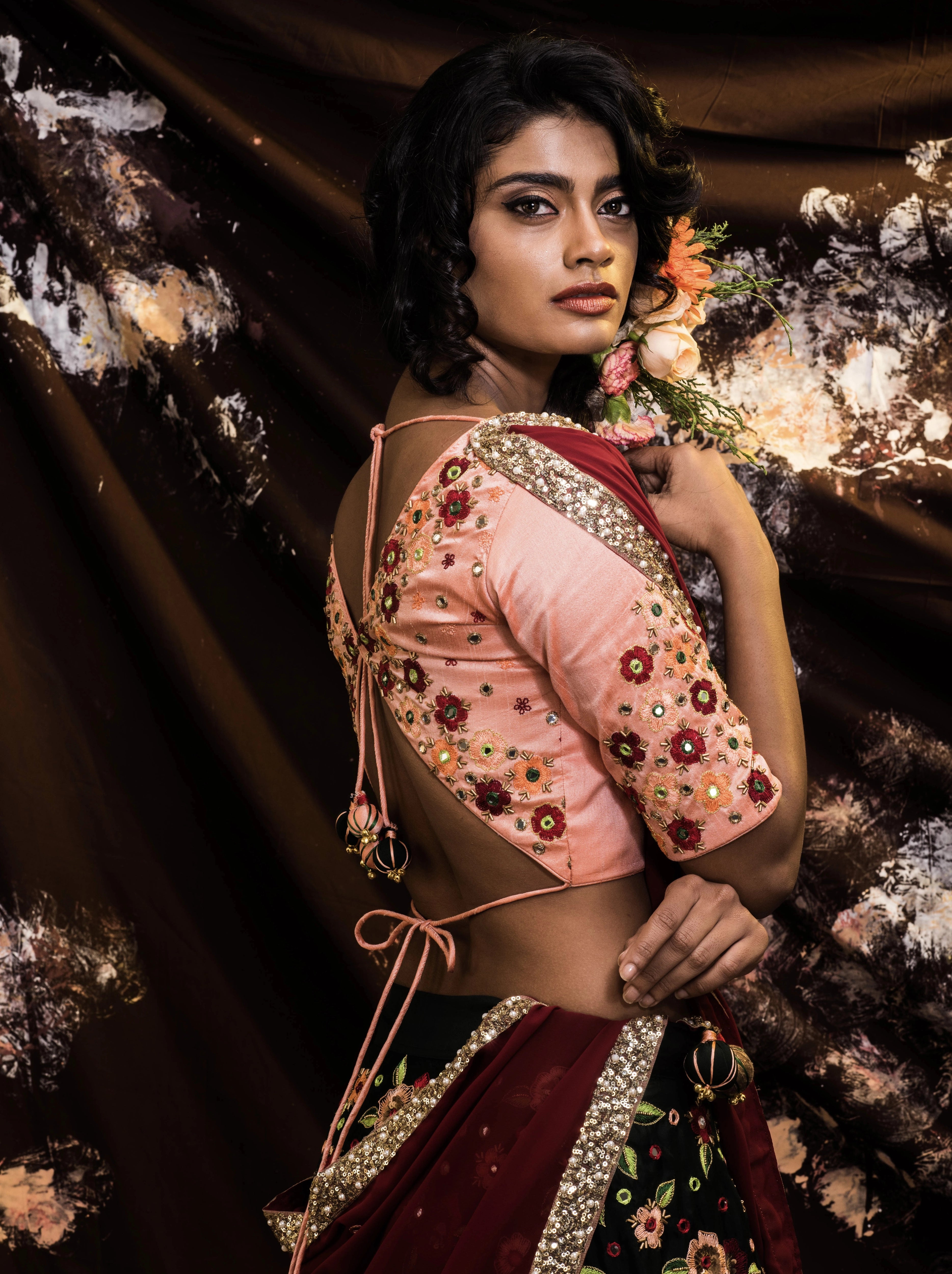 Supermodel Archana Akil Kumar showcasing blouse sleeve detailings in a rawsilk peach and bottle green lehenga with a maroon georgette dupatta intricately handcrafted by team Archana Karthick.