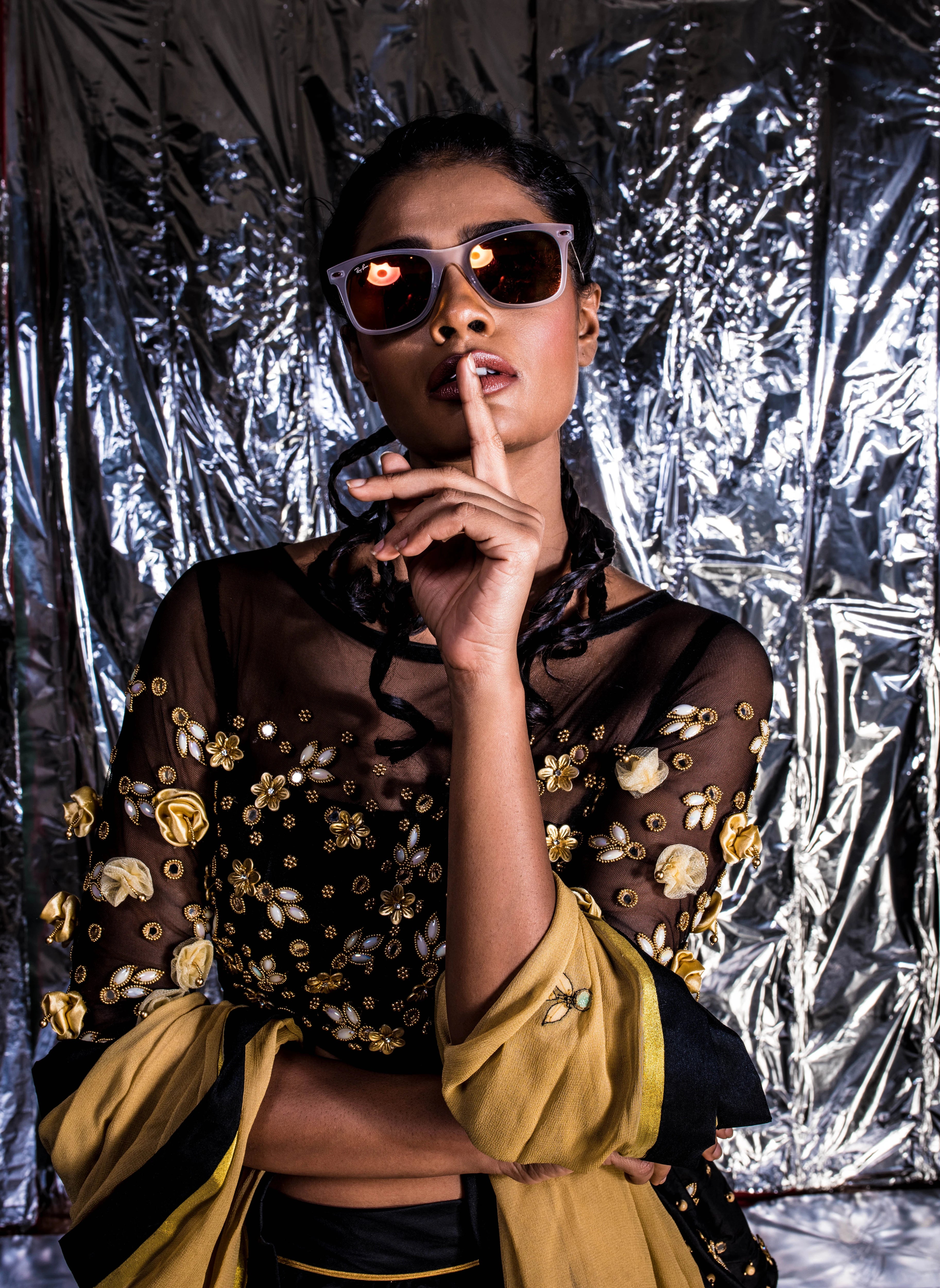 Supermodel Archana Akil Kumar telling us to keep quiet in sunglasses in a black taffeta lehenga with a gold georgette dupatta intricately handcrafted with appliques, pearls, mirror and beads.
