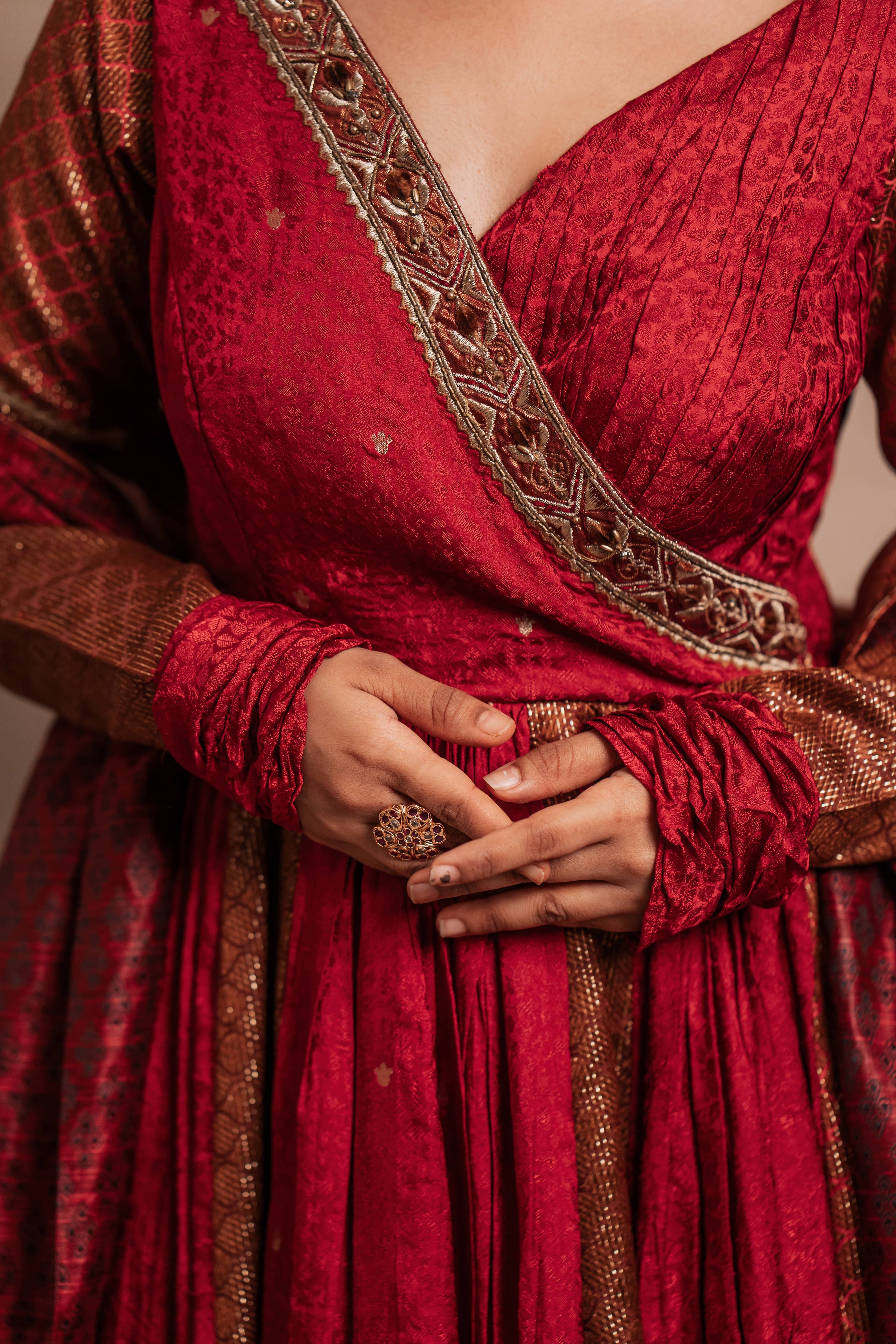 Yoke design details of a Red-orange angrakha anarkali in banarasi tissue and silk paired with a sharara pant and a delicate tissue dupatta by team Archana Karthick