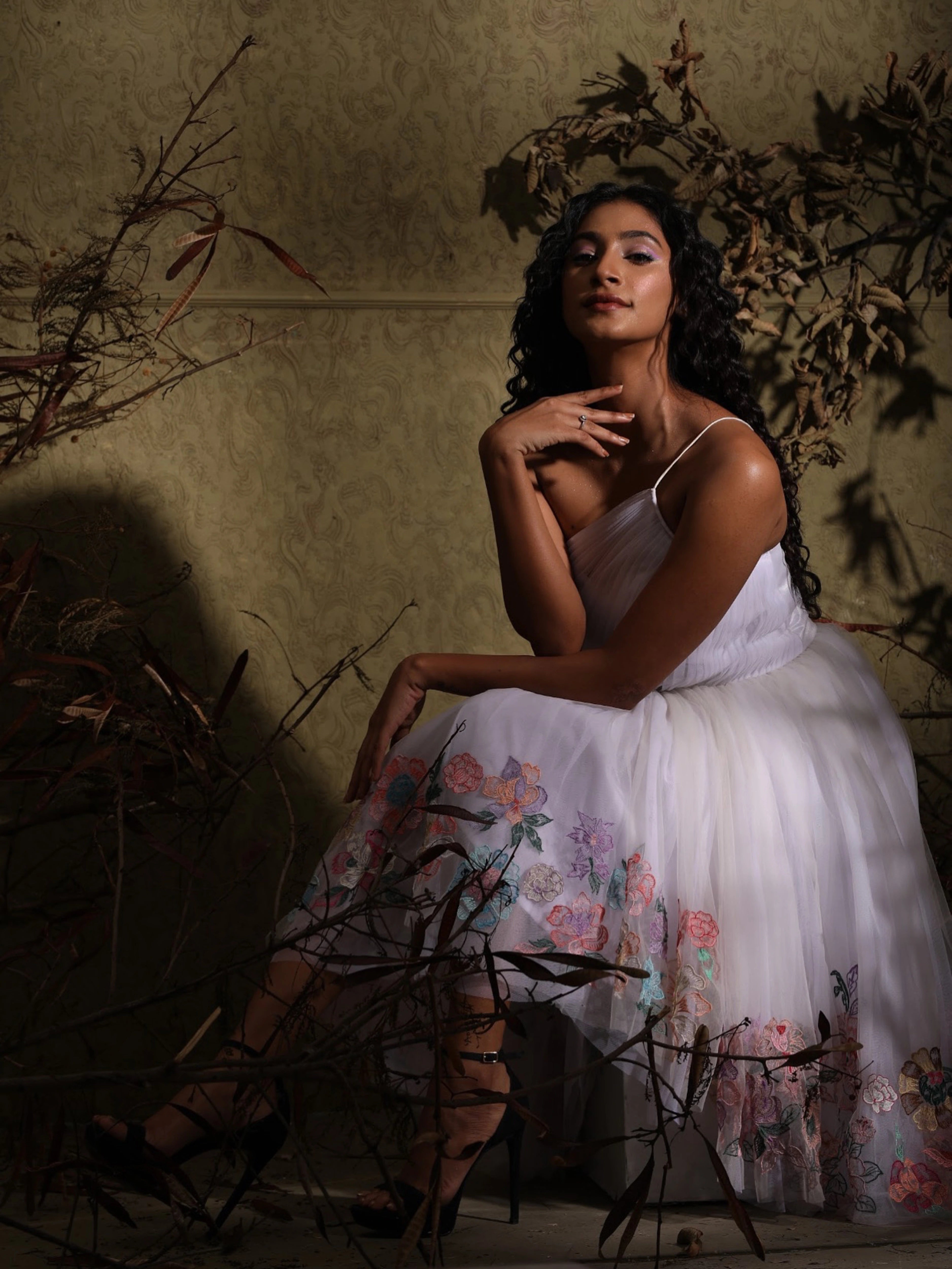 Miss India 2018 Anukreethy Vas posing gracefully in a white tulle one-shoulder dress with delicate pastel floral work, showcasing elegant Indian designer evening wear from Archana Karthick.